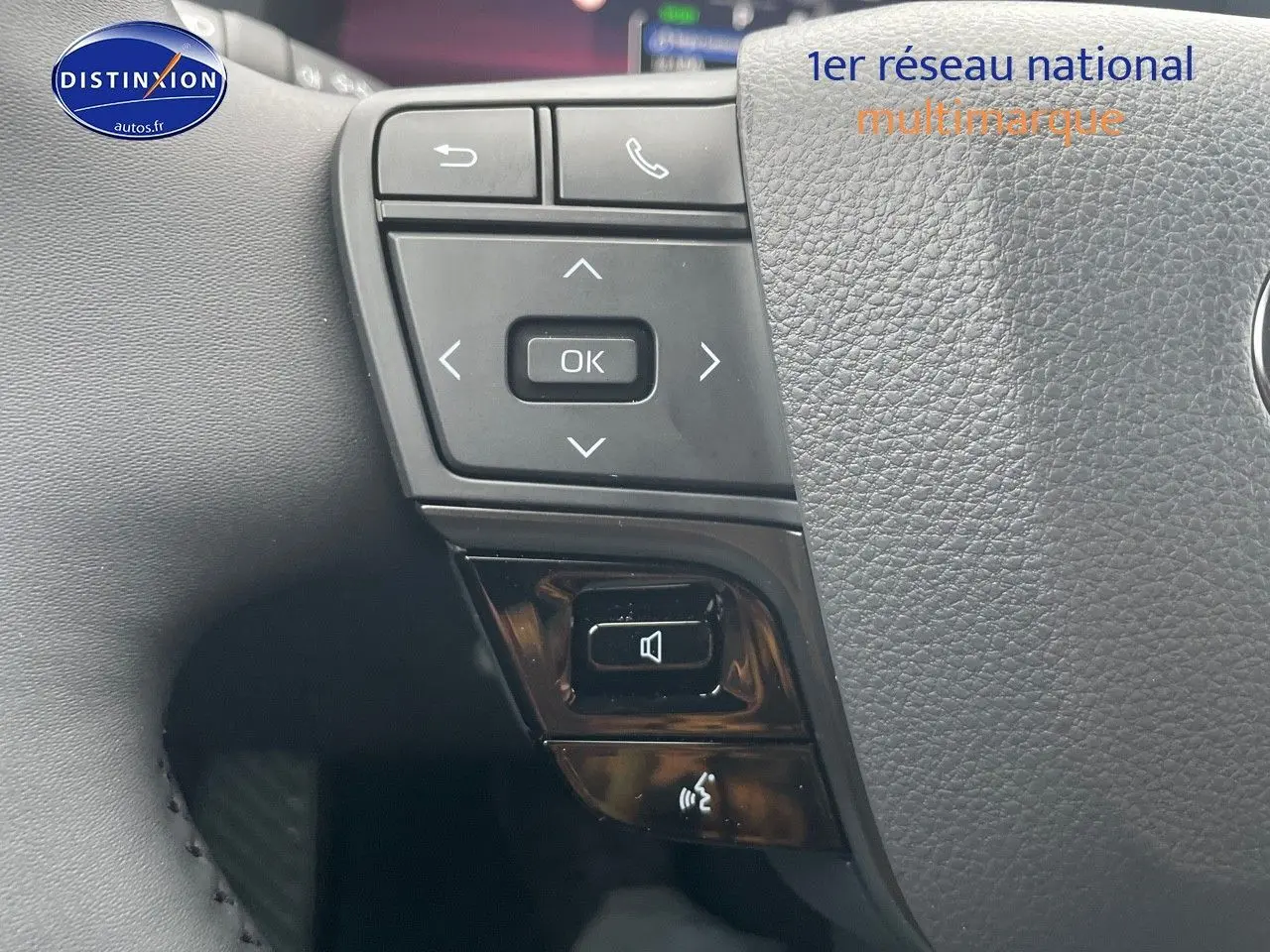 Gros plan sur les commandes au volant du Toyota C-HR 1.8 Hybrid 2024, finition Style, en cuir noir texturé.