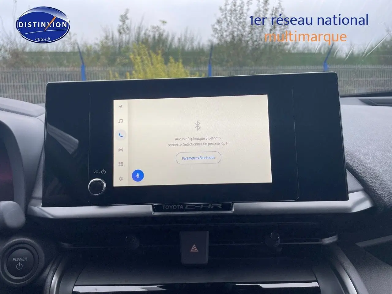 Écran tactile central allumé du Toyota C-HR 2024, vue frontale de la console intérieure avec commandes visibles.