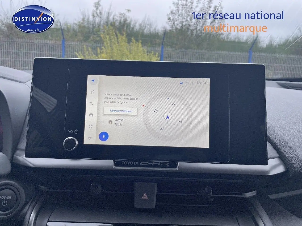 Écran tactile central du Toyota C-HR 2024 affichant une boussole, avec tableau de bord gris et volant partiel visible.