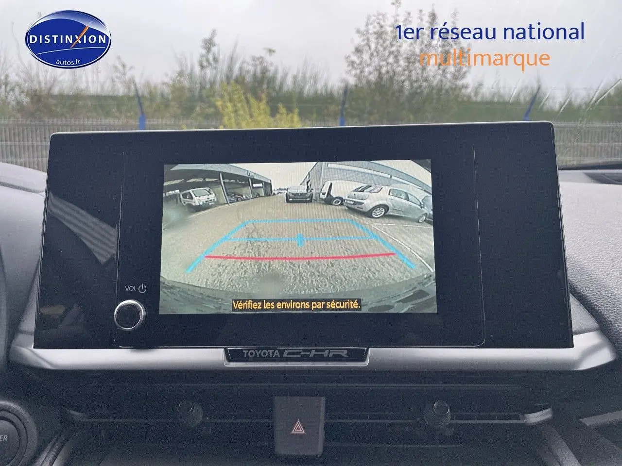 Écran central du Toyota C-HR 2024 affichant la caméra de recul avec vue sur un parking extérieur.
