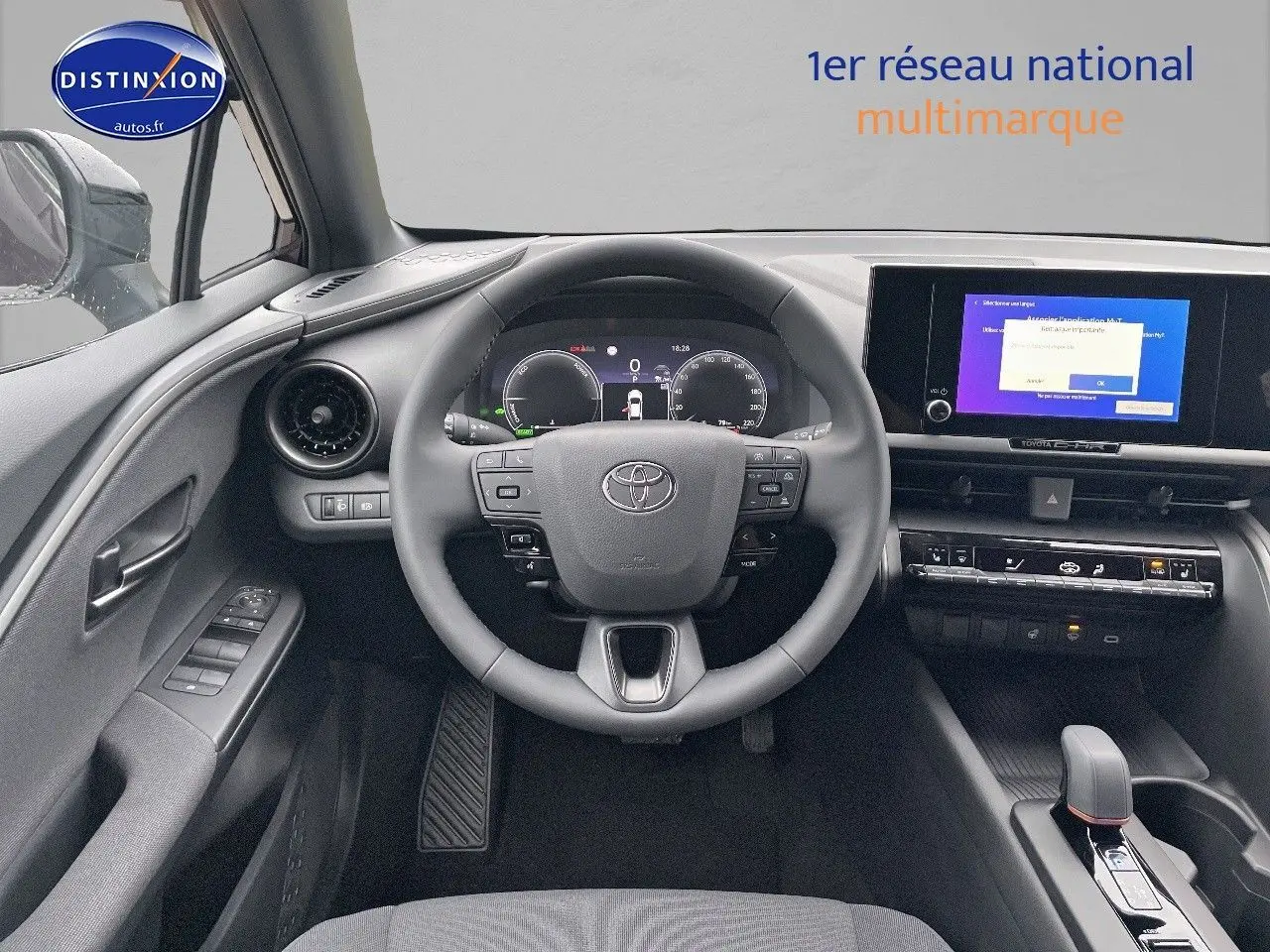 Vue frontale de l'habitacle du Toyota C-HR 1.8 Hybrid 2024 avec tableau de bord numérique et écran tactile central.