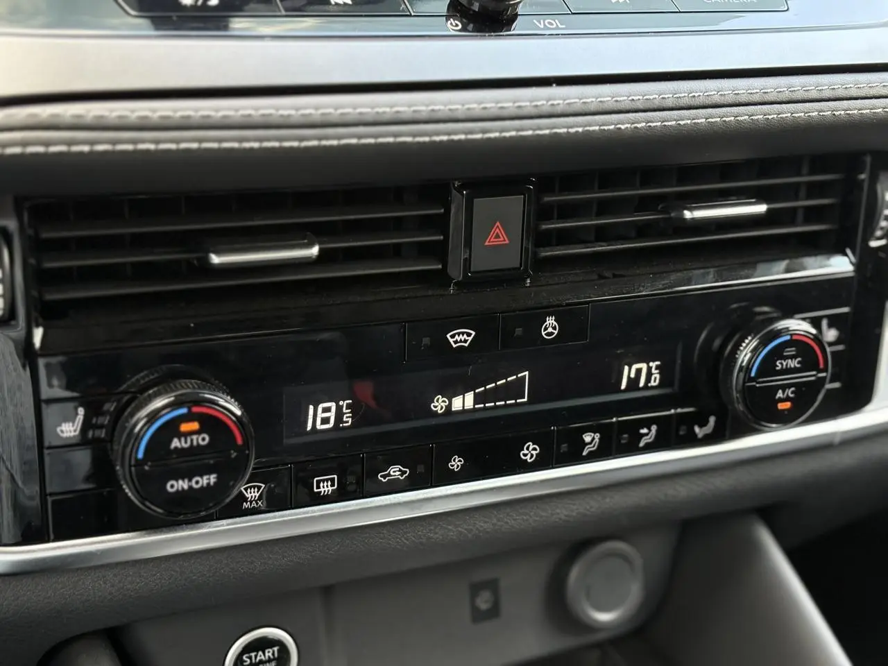 Tableau de bord du Nissan Qashqai 2025 montrant la climatisation automatique bi-zone avec commandes digitales et boutons noirs.