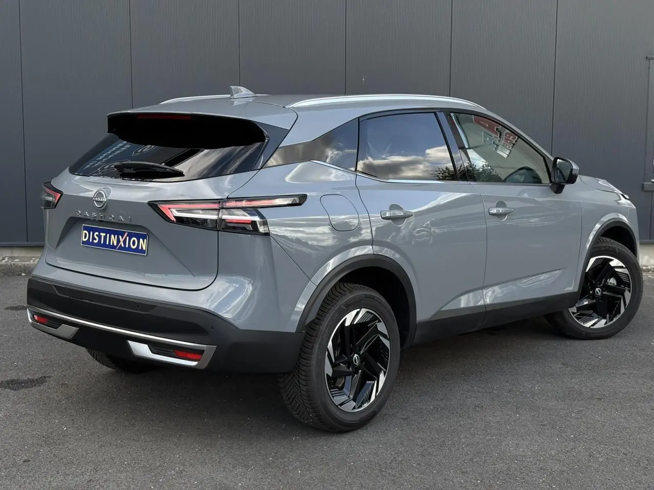 Vue 3/4 arrière droit du Nissan Qashqai gris Ceramic avec jantes alliage noires et hayon électrique fermé.