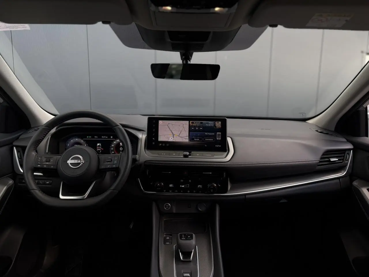 Tableau de bord et volant du Nissan Qashqai 2025 vus de face, avec écran tactile et finitions noires élégantes.