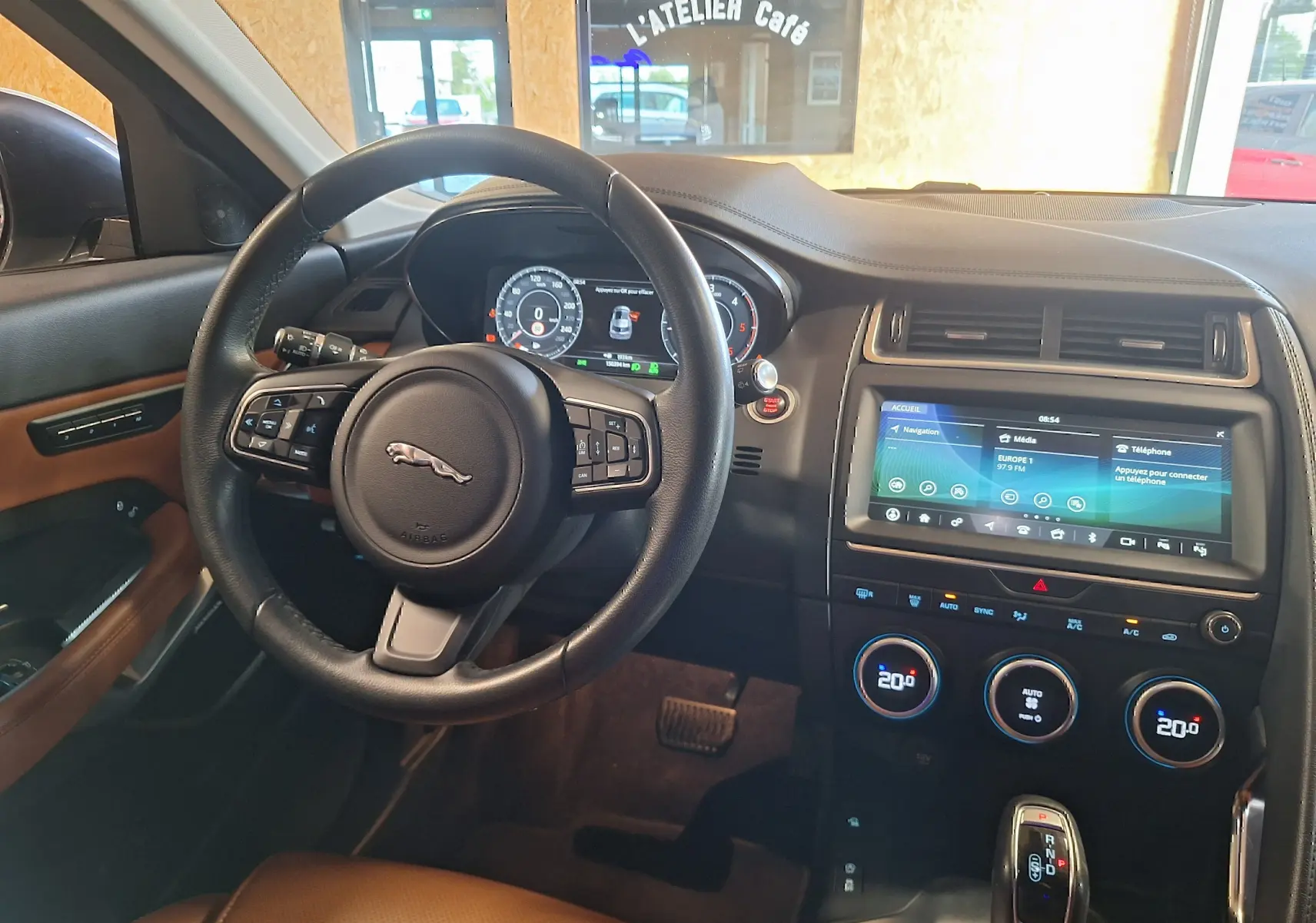 Intérieur Jaguar E-PACE 2019 vu côté conducteur, volant cuir, écran tactile 12,3 pouces et finitions marron cuir.