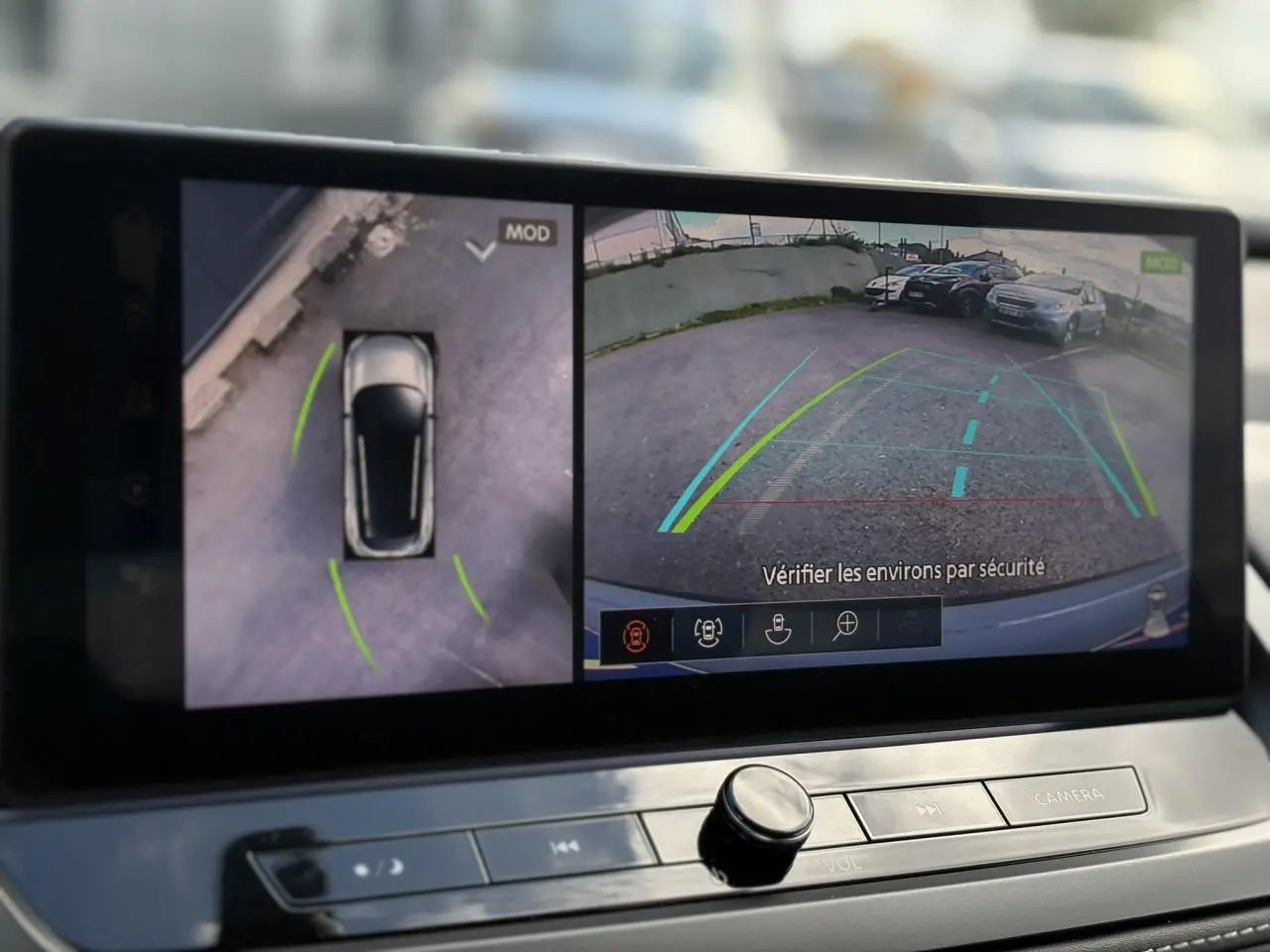 Écran multimédia du Nissan Qashqai 2025 montrant la caméra de recul et la vue 360° du véhicule en stationnement.