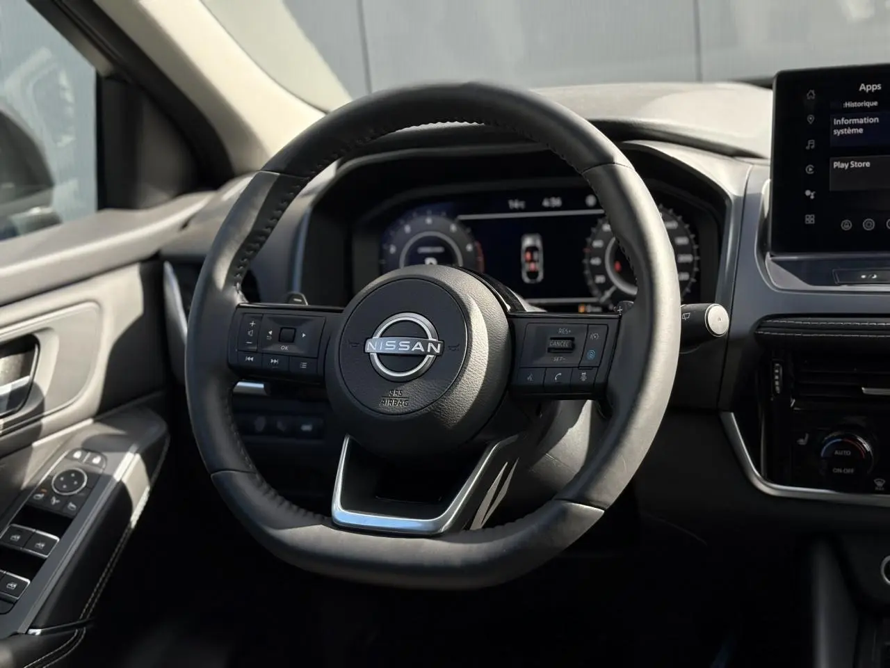 Volant cuir noir avec commandes intégrées dans l'habitacle du Nissan Qashqai III 2025, tableau de bord numérique visible