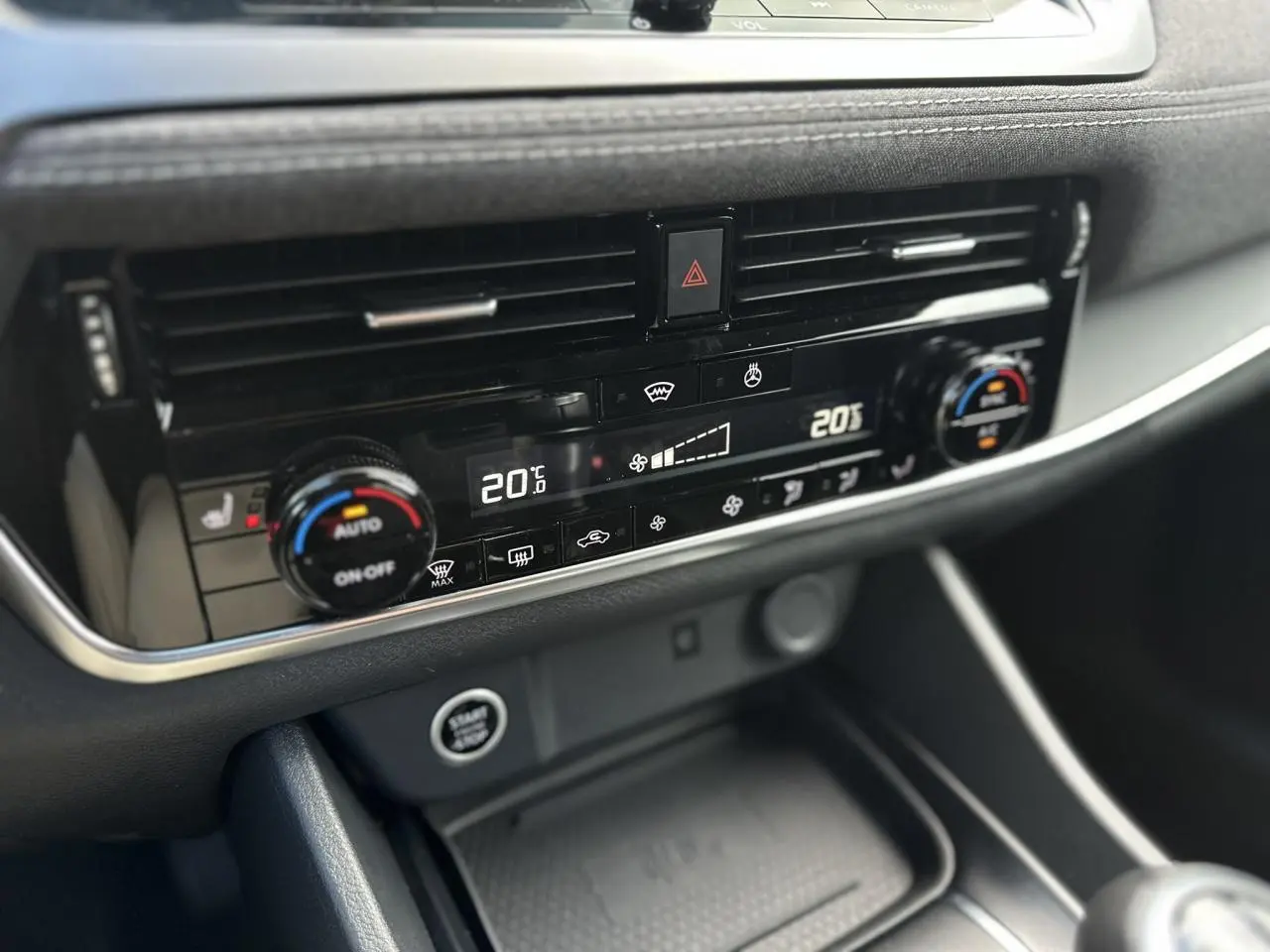 Détail de la console centrale du Nissan Qashqai 2024 montrant la climatisation automatique bi-zone et le bouton Start/Stop.