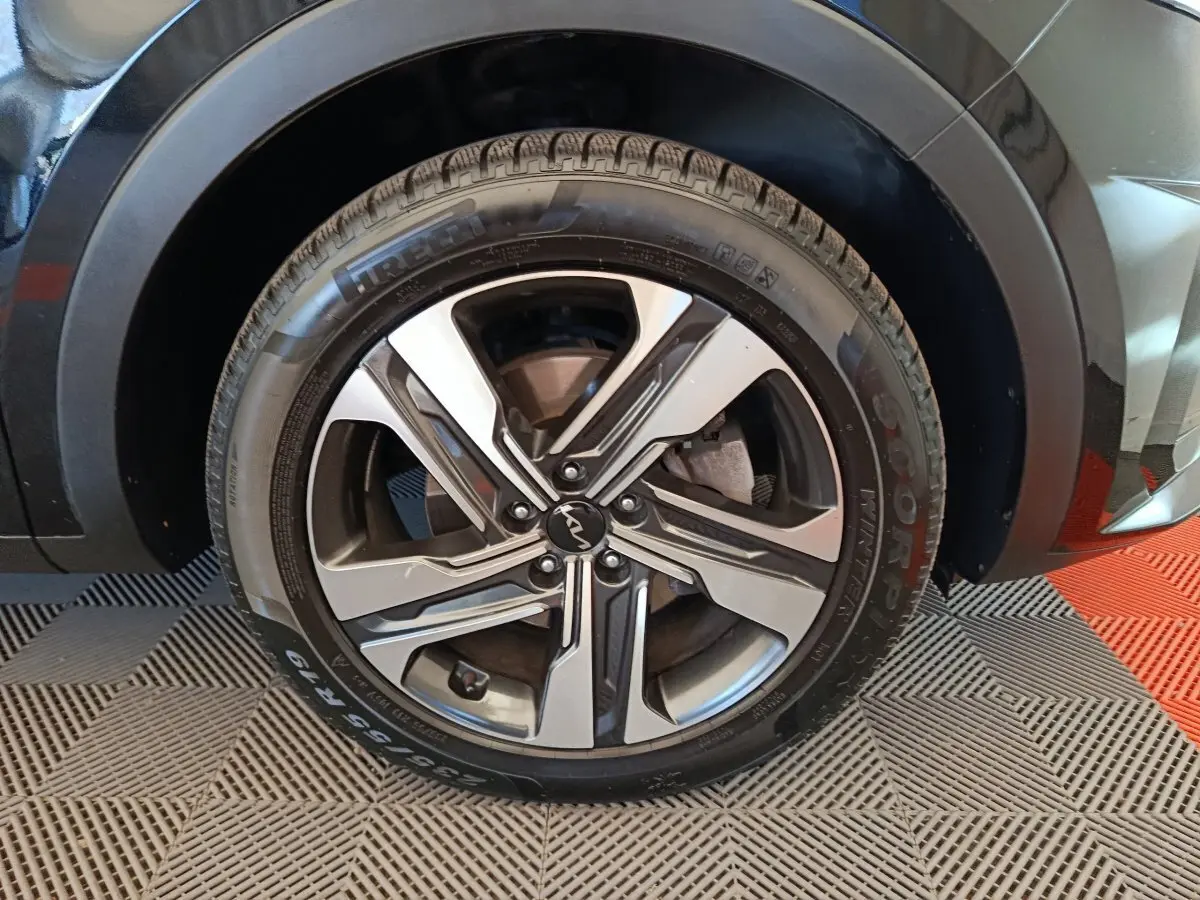 Gros plan sur la roue avant droite du KIA Sorento noir, avec jante alliage bicolore et logo central Kia.