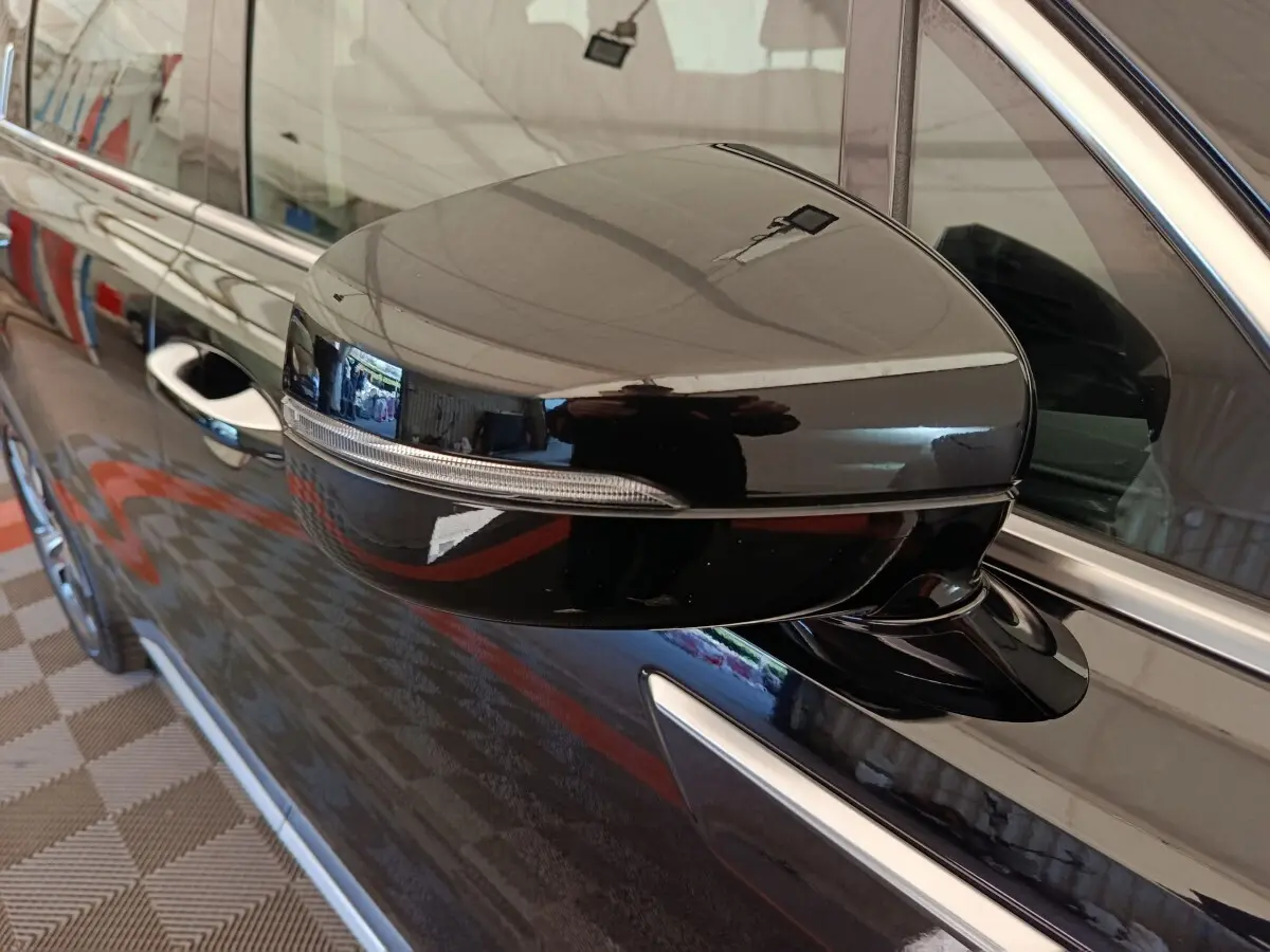 Rétroviseur droit noir brillant du KIA Sorento 2023 hybride rechargeable, avec clignotant intégré et poignée de porte visible.
