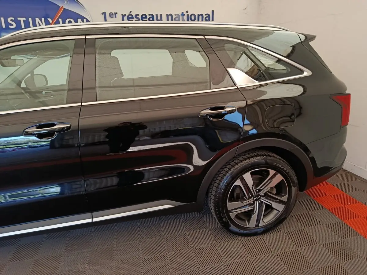 Vue latérale côté droit du Kia Sorento noir 2023, mettant en valeur la jante alliage et les lignes chromées sur les portes.