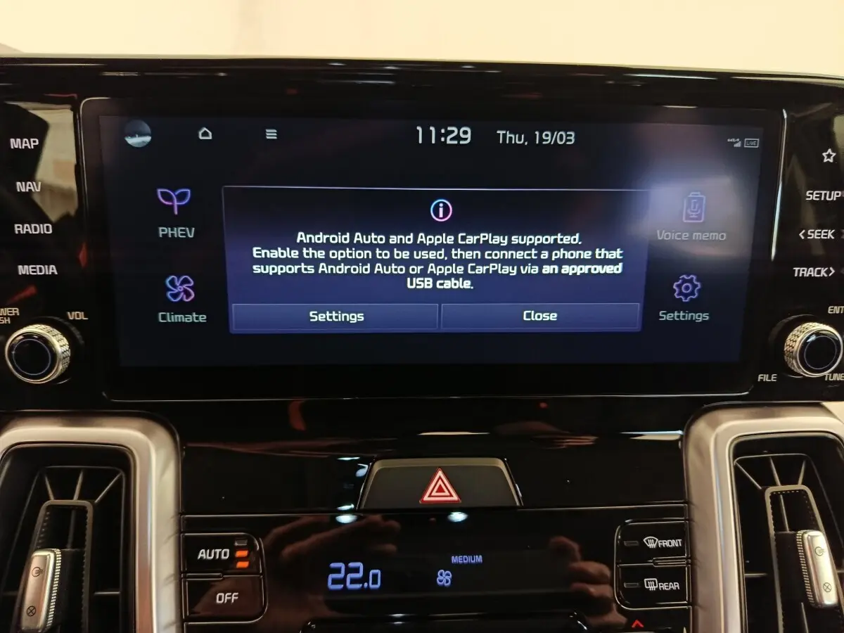 Écran tactile central du tableau de bord du Kia Sorento noir 2023, affichant options Android Auto et Apple CarPlay.