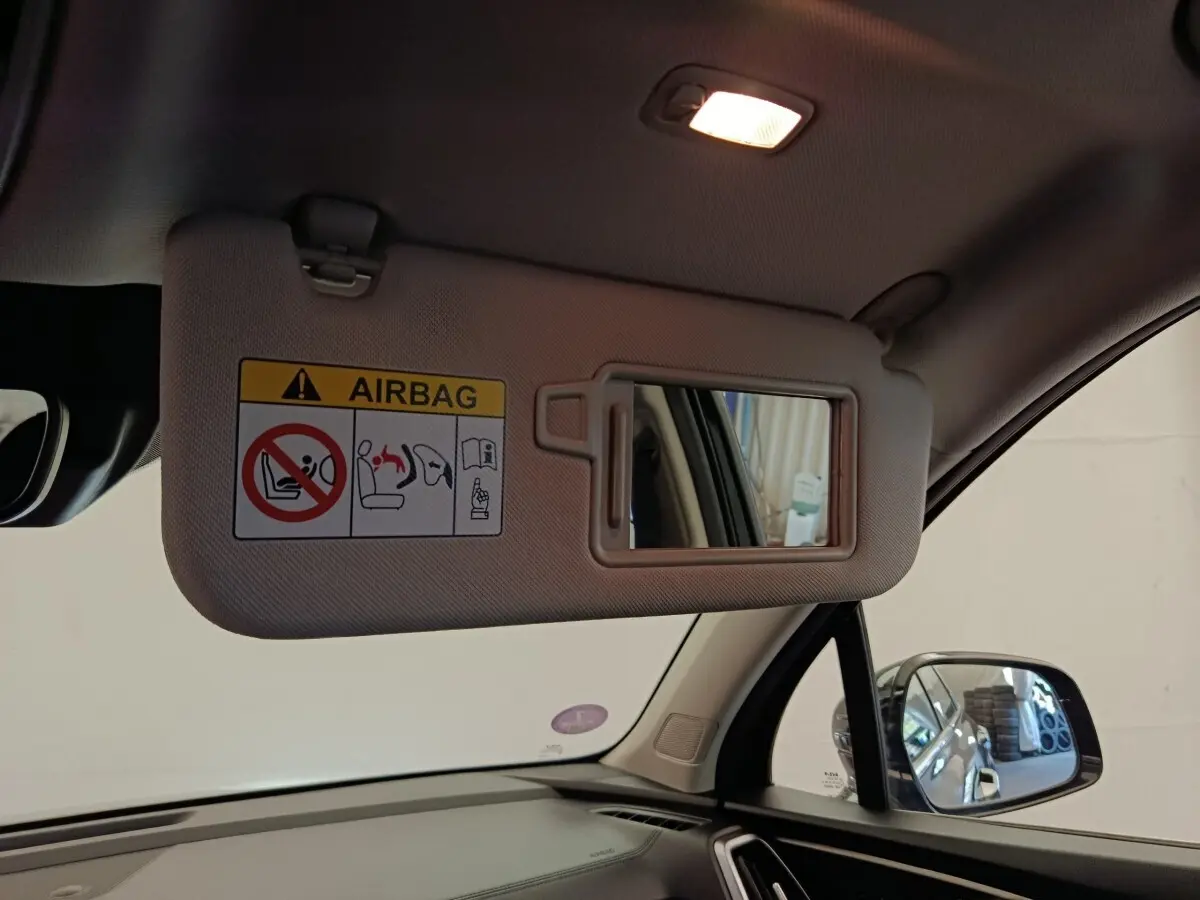 Vue intérieure côté conducteur du pare-soleil beige avec miroir et avertissement airbag du Kia Sorento noir 2023.