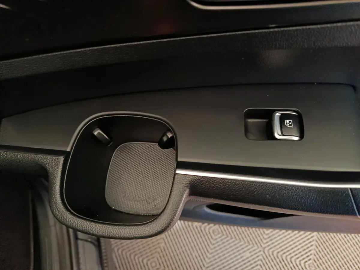 Gros plan sur la commande de lève-vitre et porte-gobelet côté conducteur du KIA Sorento noir 2023.