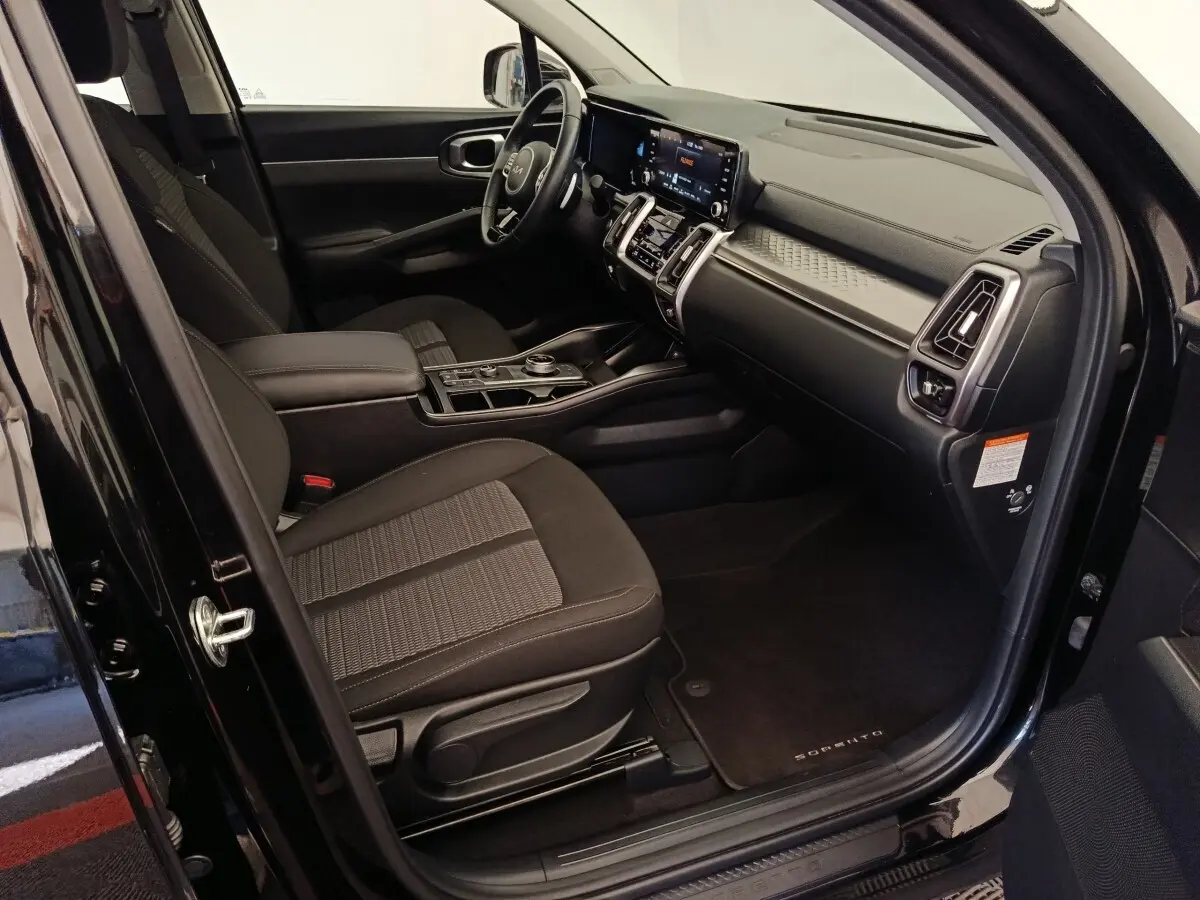 Intérieur côté conducteur du KIA Sorento noir 2023, avec tableau de bord moderne et écran tactile central.