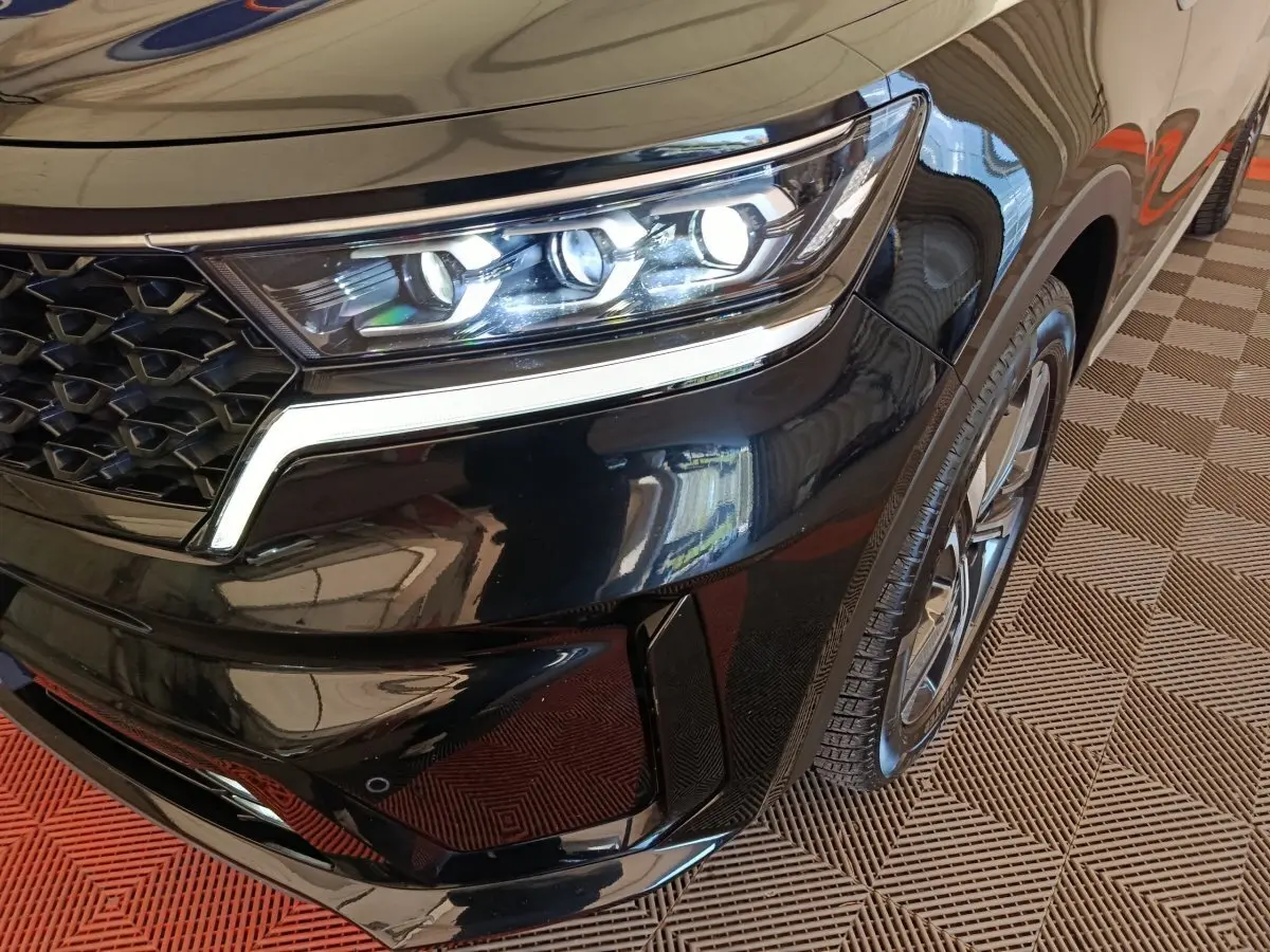 Gros plan sur l’avant droit noir du KIA Sorento 2023, mettant en valeur le phare LED et la calandre distinctive.