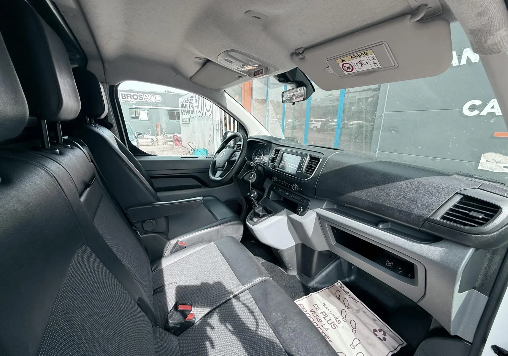 Vue intérieure côté conducteur du Citroën Jumpy XL 2017, sièges noirs et tableau de bord avec écran central.