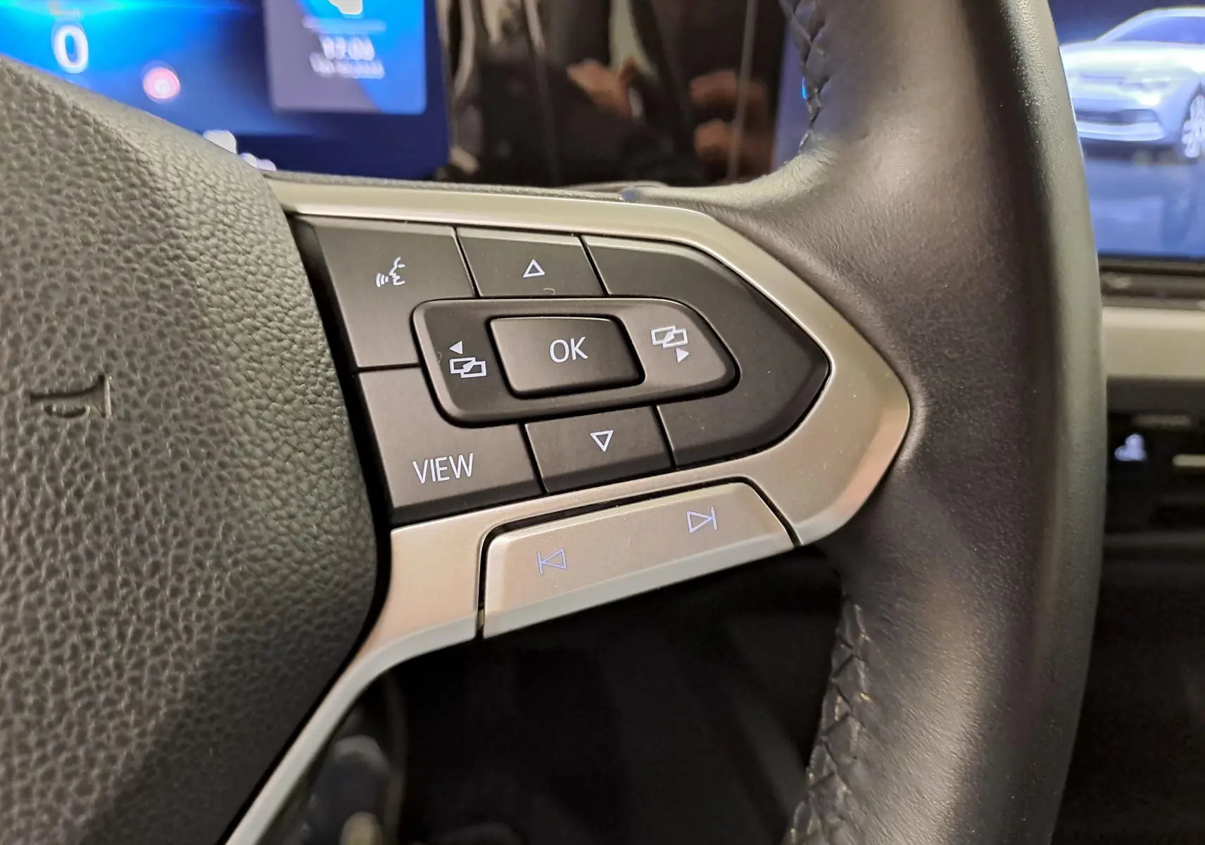 Gros plan sur les commandes multifonctions à droite du volant noir de la Volkswagen Golf 2022.