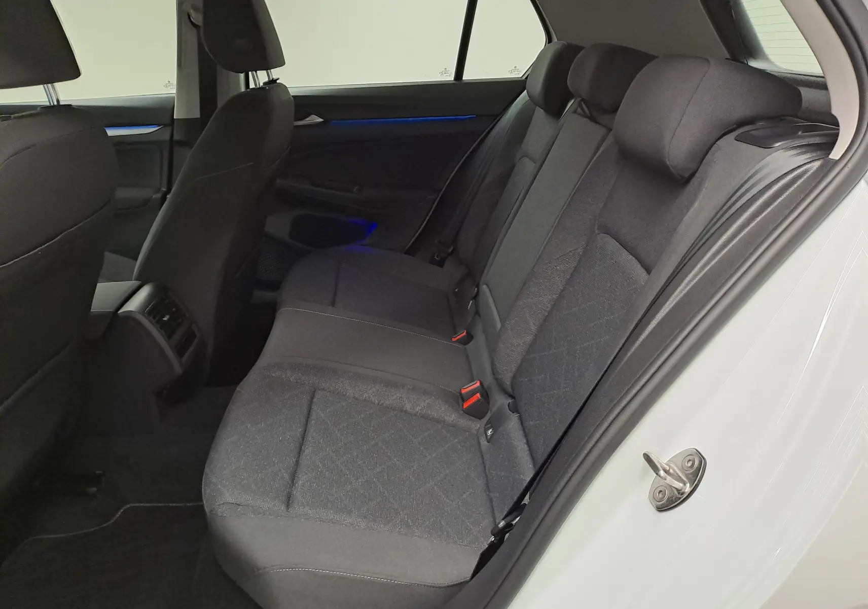 Vue intérieure côté droit des sièges arrière en tissu gris de la Volkswagen Golf 1.5 TSI 2022 blanche.