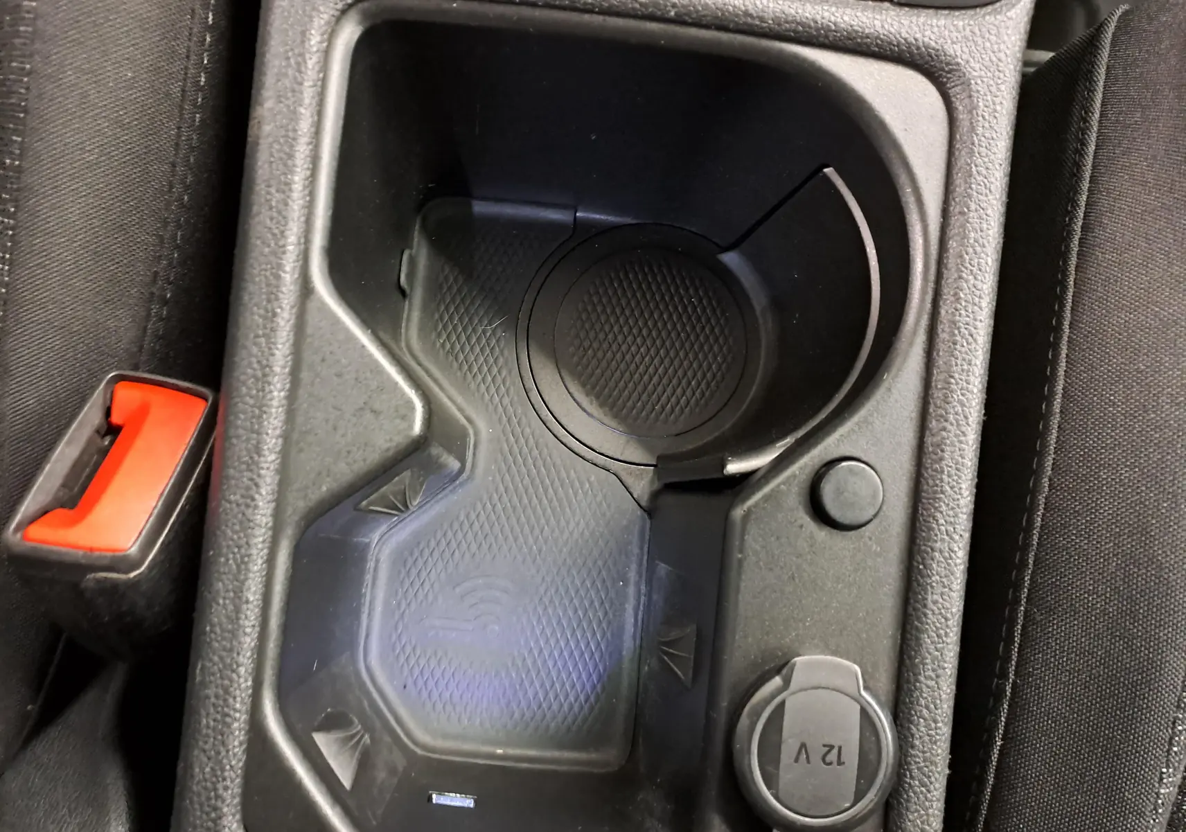 Gros plan sur le porte-gobelet et prise 12V dans l'habitacle noir de la Volkswagen Golf 2022 Blanc Pur.