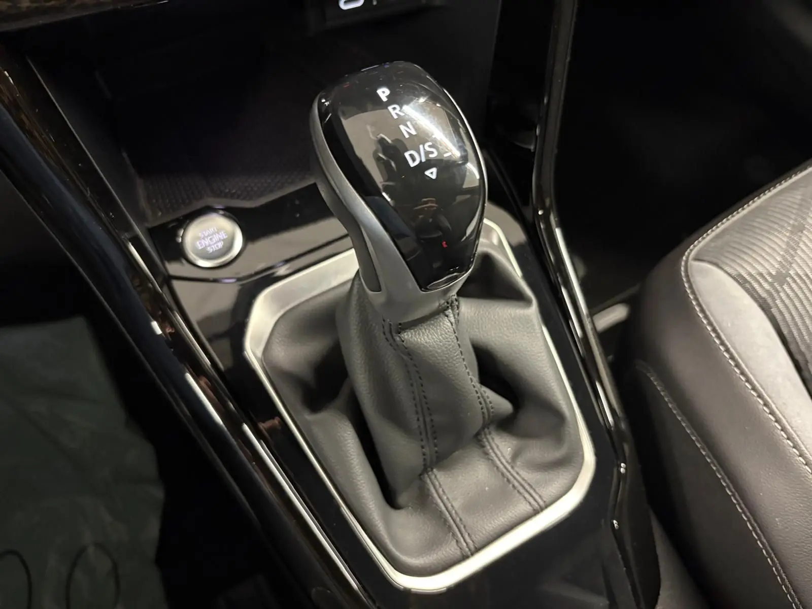 Le levier de vitesse automatique du Volkswagen T-Roc 2024 R-Line, entouré de cuir noir et bouton start/stop visible.