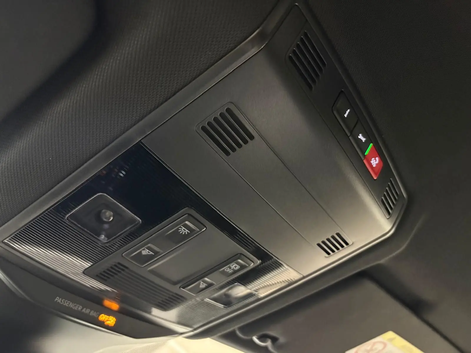 Plafonnier intérieur avec commandes d’éclairage et alerte d’airbag passager du Volkswagen T-Roc bleu pétrole 2024 R-Line.