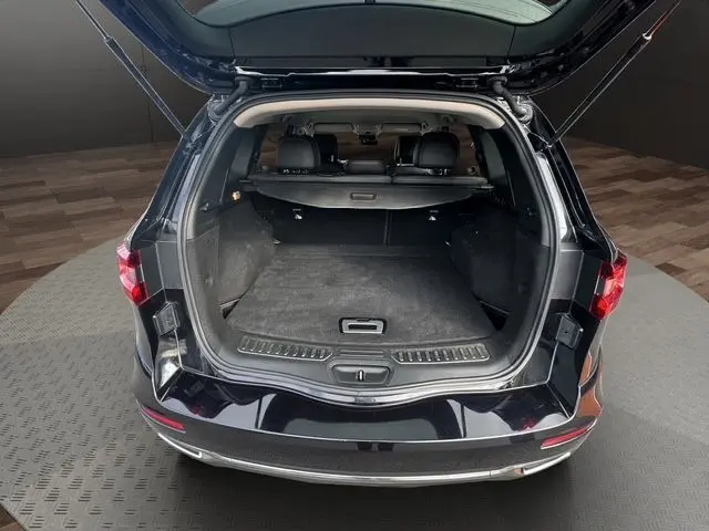 Coffre ouvert vu de l'arrière d'un Renault Koleos noir 2017, montrant l'espace de chargement et la banquette arrière en cuir.