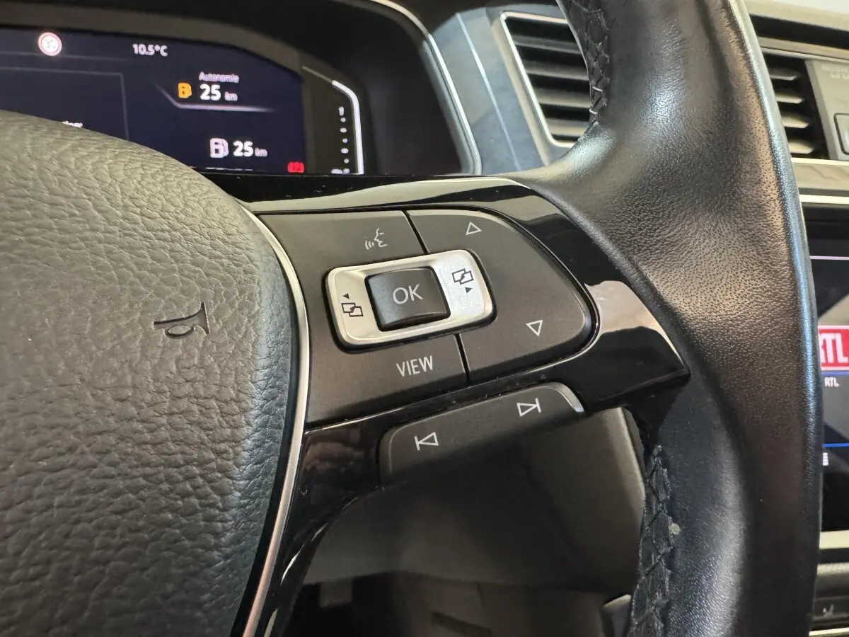 Gros plan sur le volant cuir noir du Volkswagen Tiguan Allspace 2019, avec commandes multifonctions et affichage digital visible.