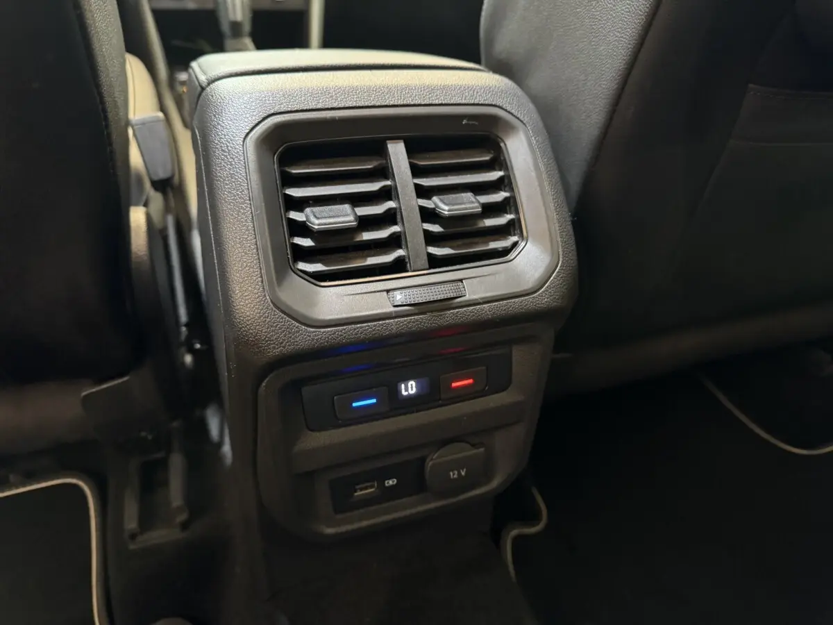 Détail de la console arrière avec bouches d’aération, commandes climatisation et prises USB et 12V du Volkswagen Tiguan Allspace gris foncé.