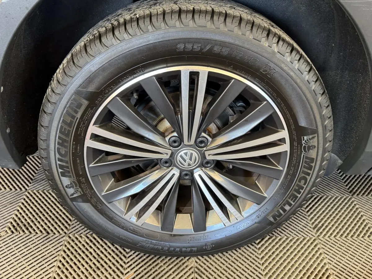 Gros plan sur la jante alliage grise et pneu Michelin d'un Volkswagen Tiguan Allspace gris foncé, roue avant droite.