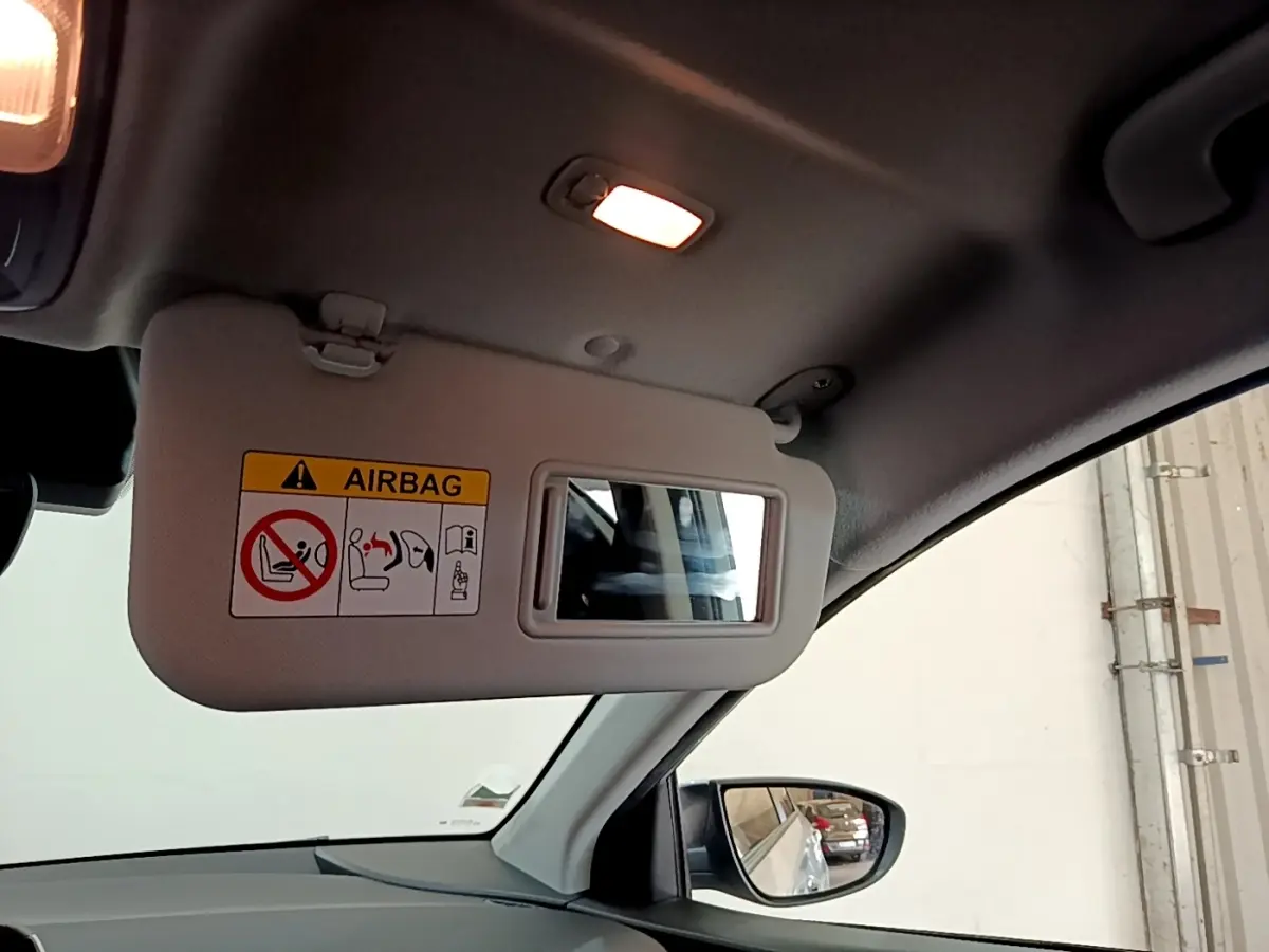 Vue intérieure du pare-soleil côté conducteur gris clair avec miroir et avertissement airbag sur Hyundai i20 2022.