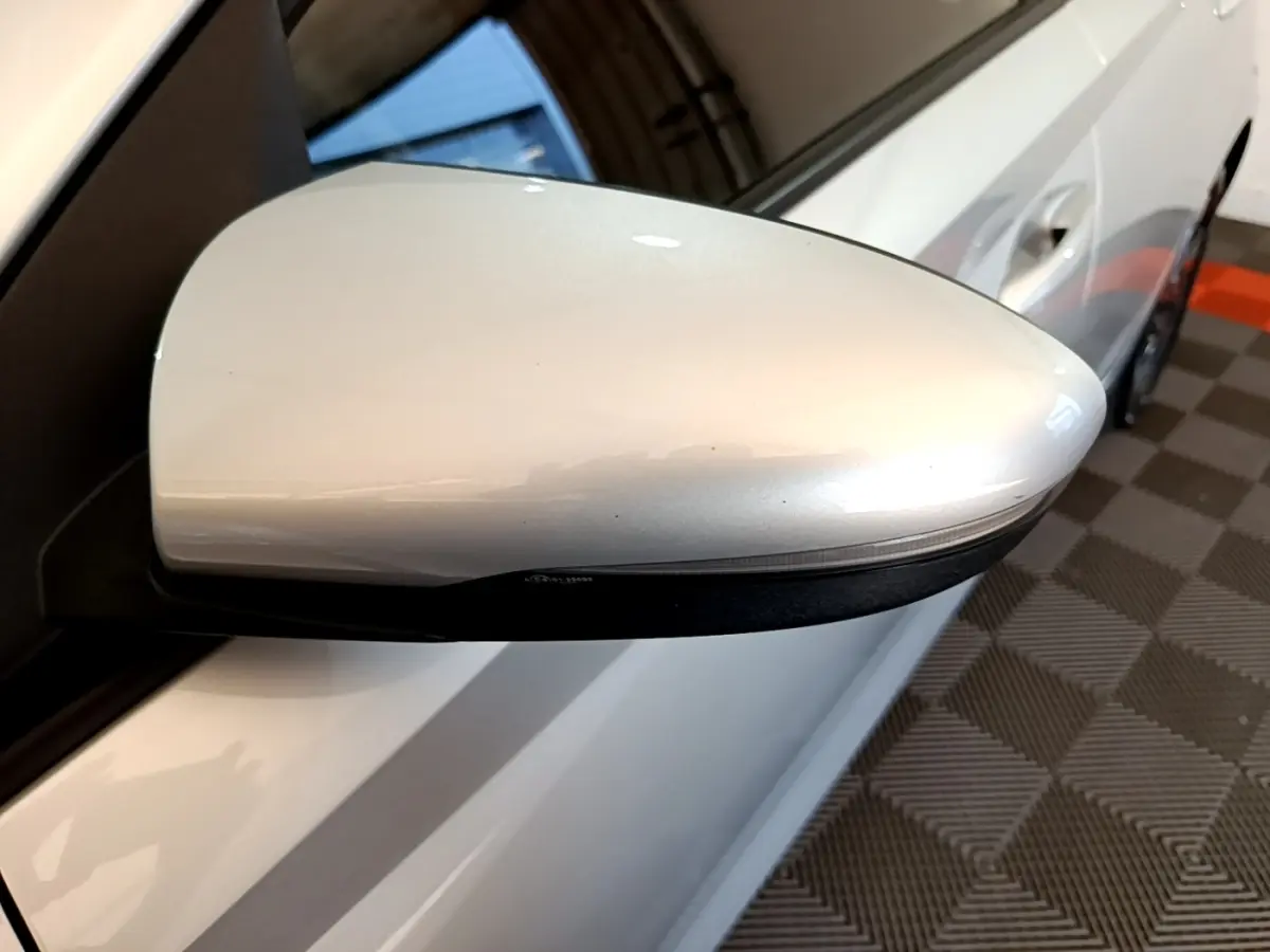 Rétroviseur droit gris clair de la Hyundai i20 2022, vue rapprochée sur la portière et poignée côté droit.