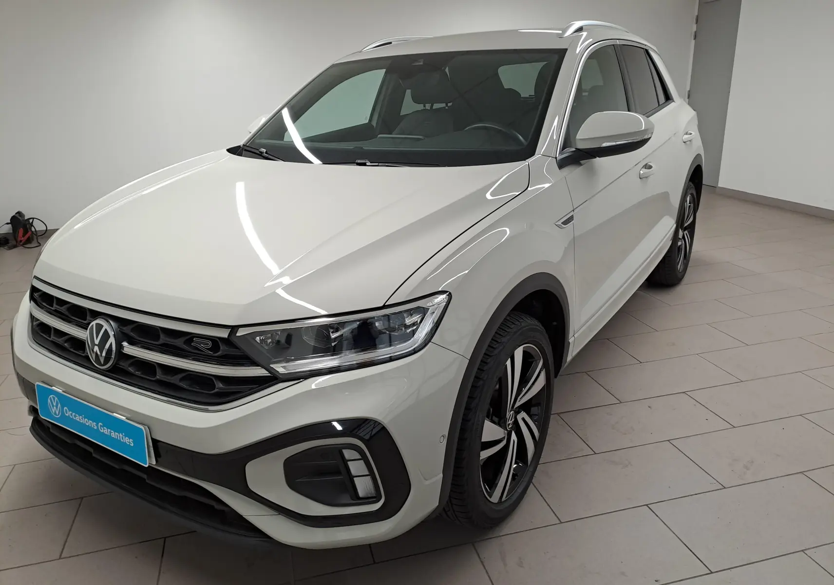 Volkswagen T-Roc blanc en 3/4 avant droit, avec calandre R-Line et jantes alliage distinctives.