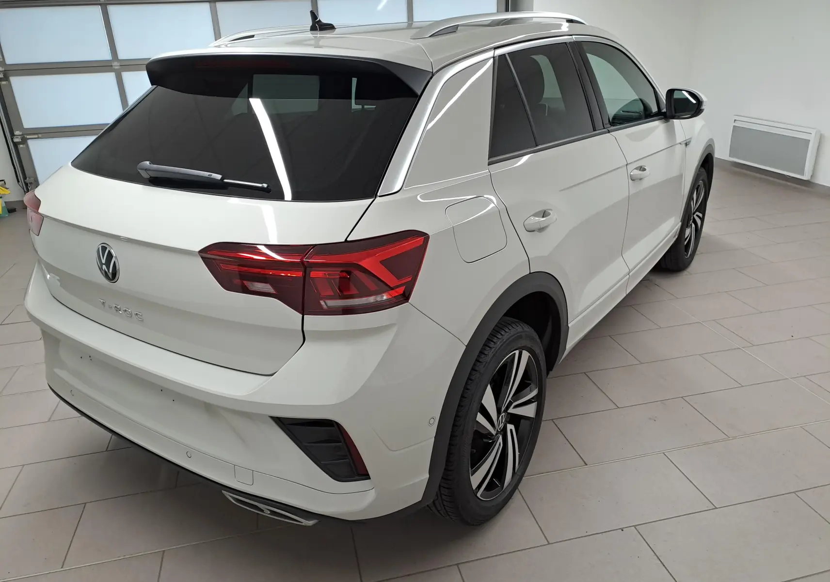 Vue 3/4 arrière droite du Volkswagen T-Roc 2024 en Gris Ascot avec jantes alliage et vitres teintées.