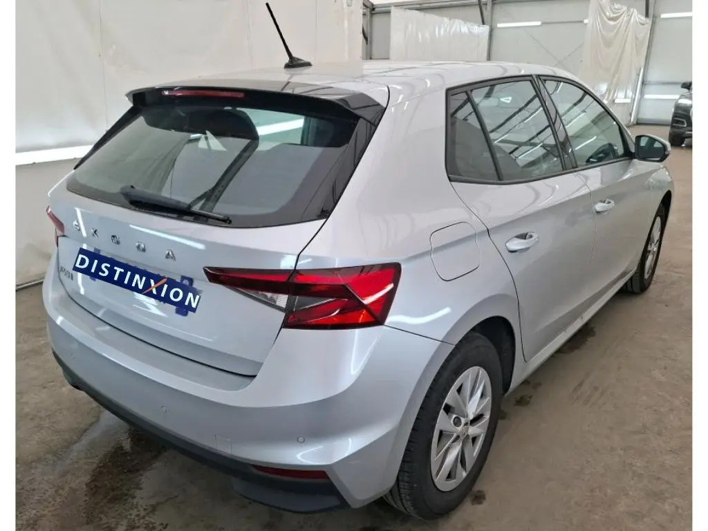 Vue 3/4 arrière droite d'une Skoda Fabia gris clair 2023 avec feux arrière LED et antenne sur le toit.