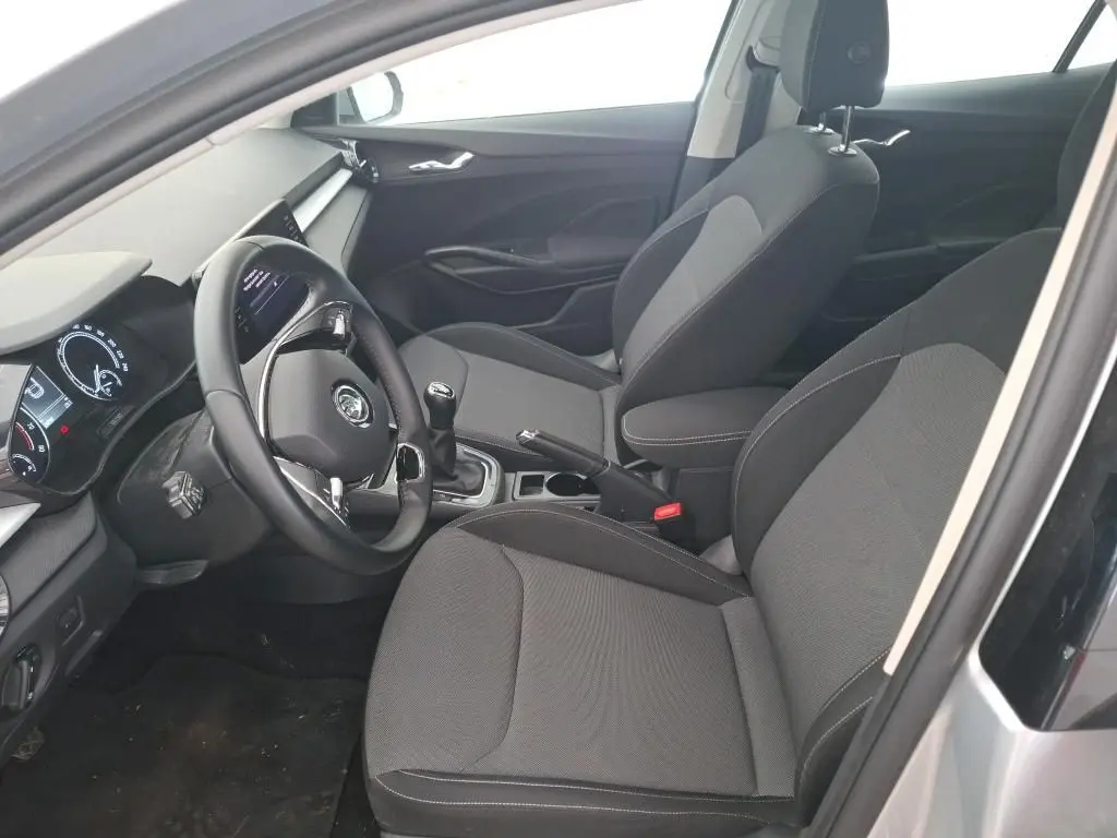 Vue intérieure côté conducteur de la Skoda Fabia Ambition 2023, sièges gris et volant avec boîte manuelle.
