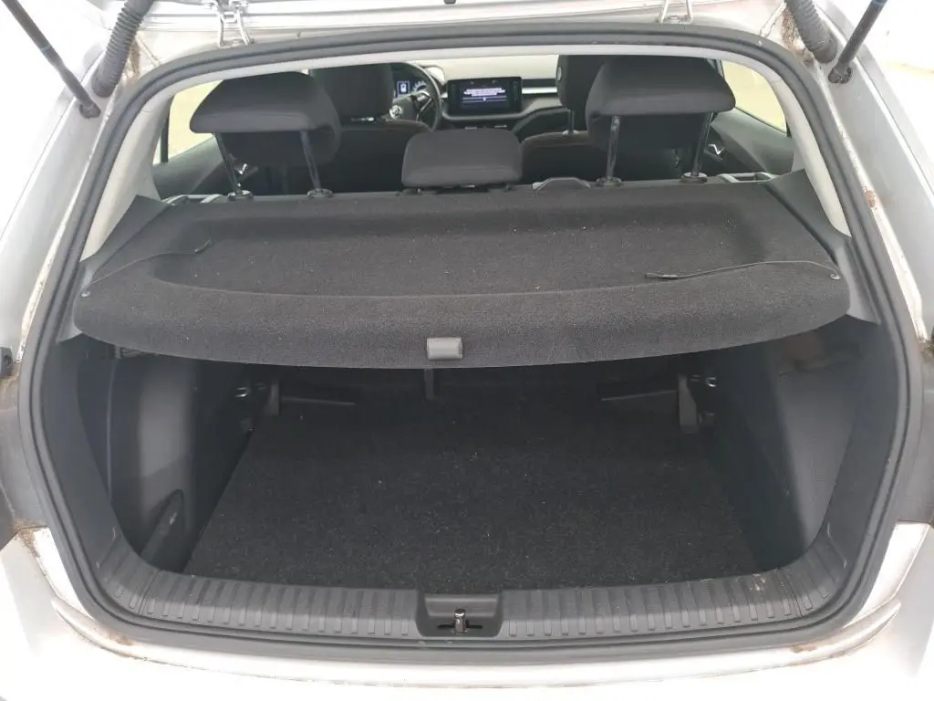 Vue arrière du coffre ouvert d'une Skoda Fabia gris 2023, avec la plage arrière en place et l'intérieur visible.
