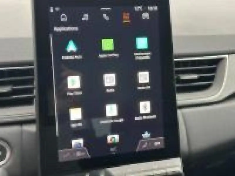 Écran tactile central en gros plan dans l’habitacle du Renault Captur rouge, affichant les applications connectées.