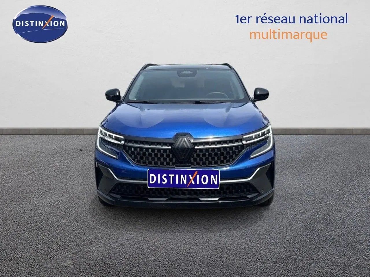 Vue avant d'un Renault Austral 2024 bleu Iron Metal avec toit noir, mettant en valeur sa calandre moderne et ses phares LED.