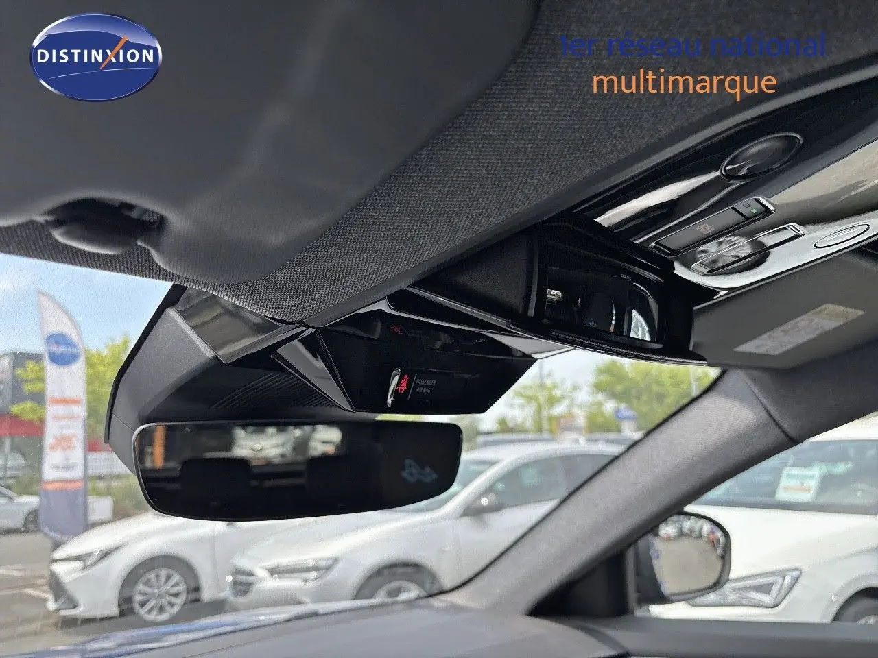 Vue intérieure du rétroviseur central et du plafonnier du Renault Austral 2024 bleu Iron Metal avec toit noir.