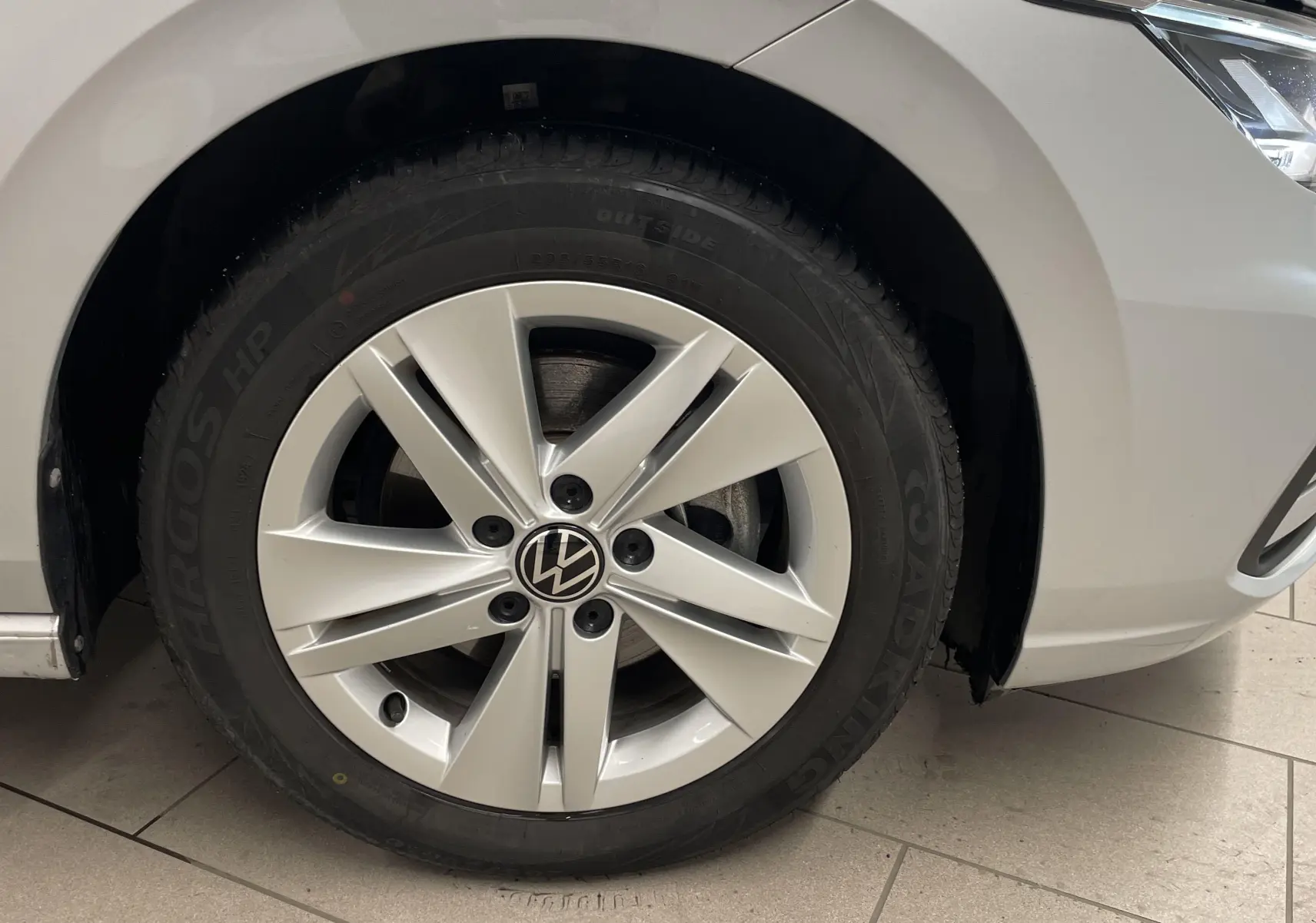 Gros plan sur la roue avant gauche d'une Volkswagen Golf 2.0 TDI 115 argent avec jante alliage cinq branches.