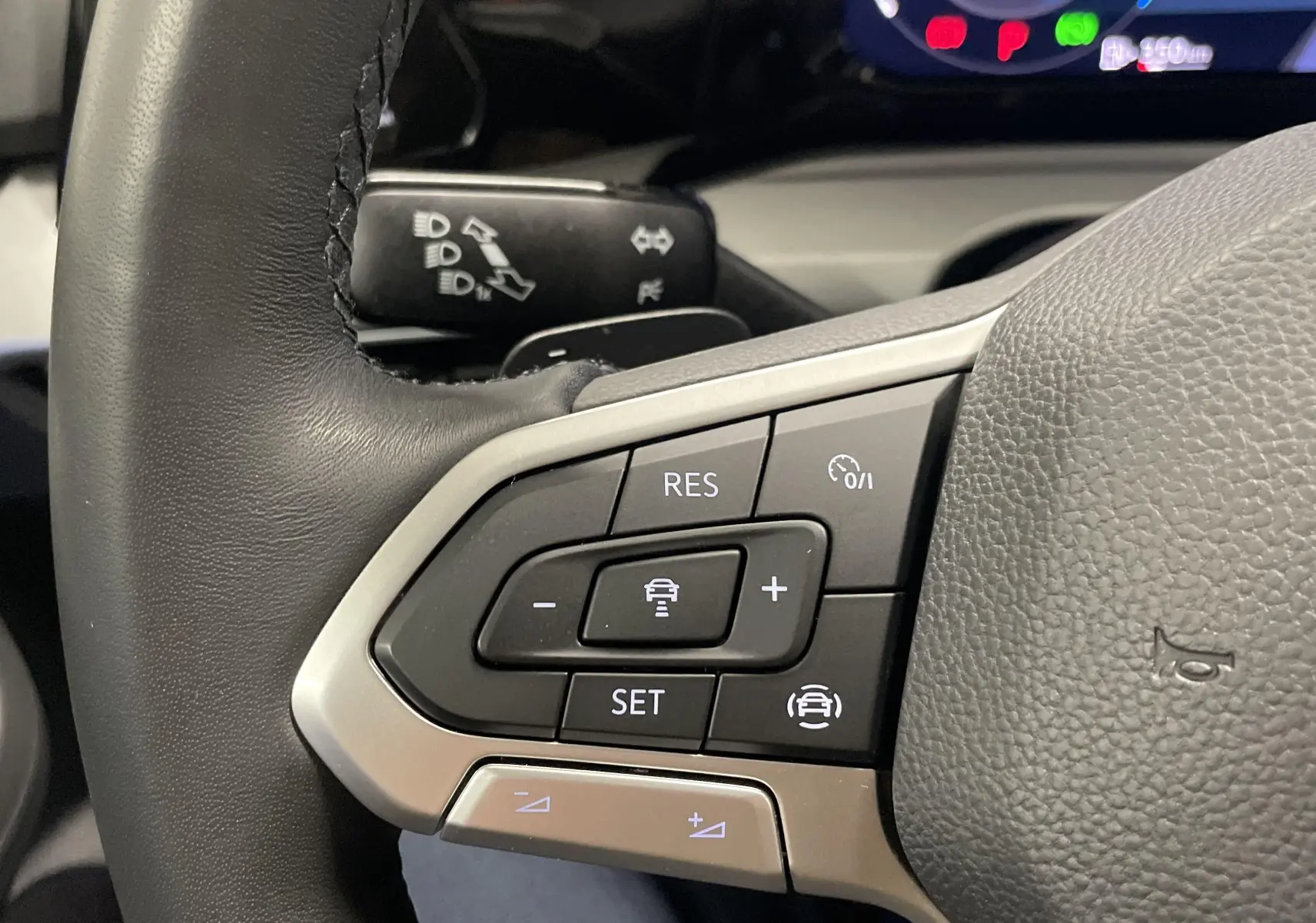 Gros plan sur les commandes au volant d'une Volkswagen Golf 2022, finition Life Business, cuir noir et boutons multifonctions.