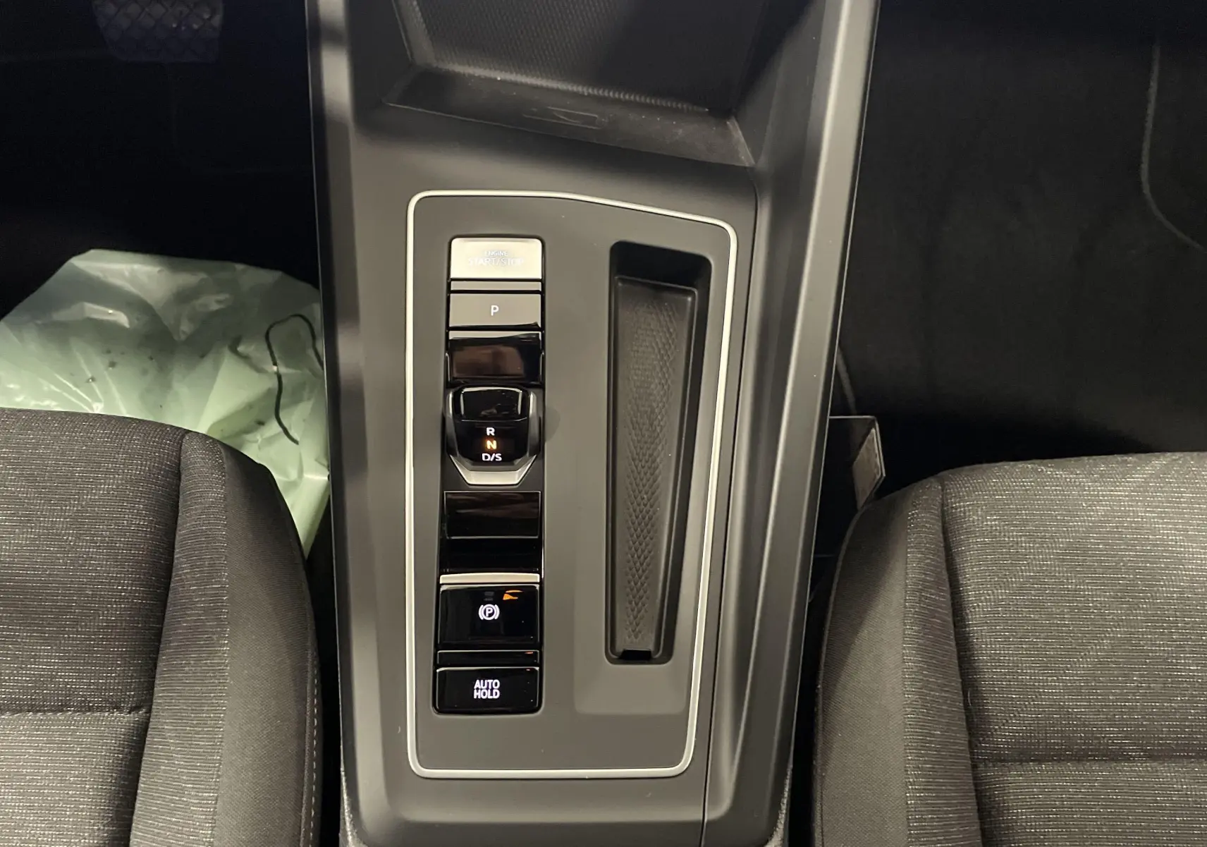 Vue rapprochée de la console centrale de la Volkswagen Golf 2.0 TDI 2022, avec commandes de boîte auto et frein électrique.