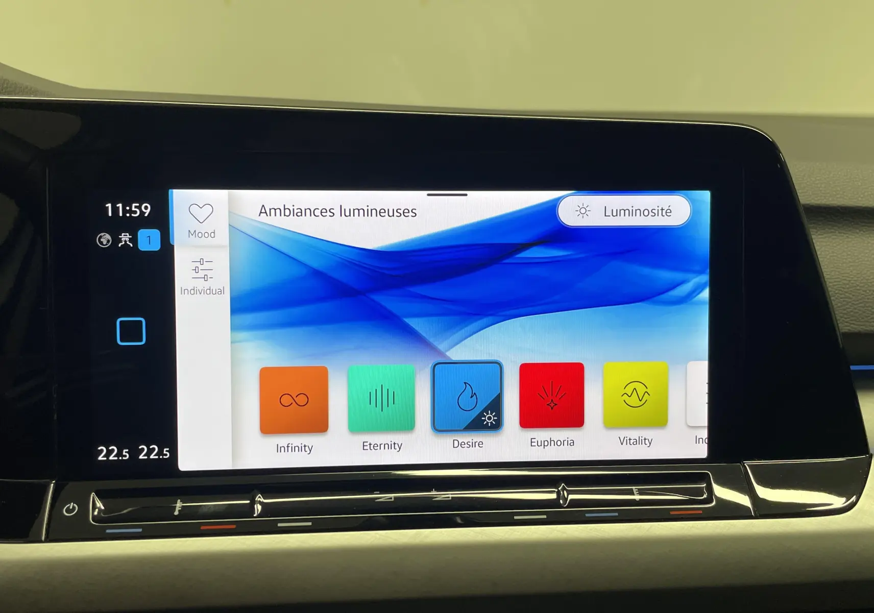 Écran tactile central affichant les réglages d'ambiances lumineuses dans une Volkswagen Golf argentée de 2022.
