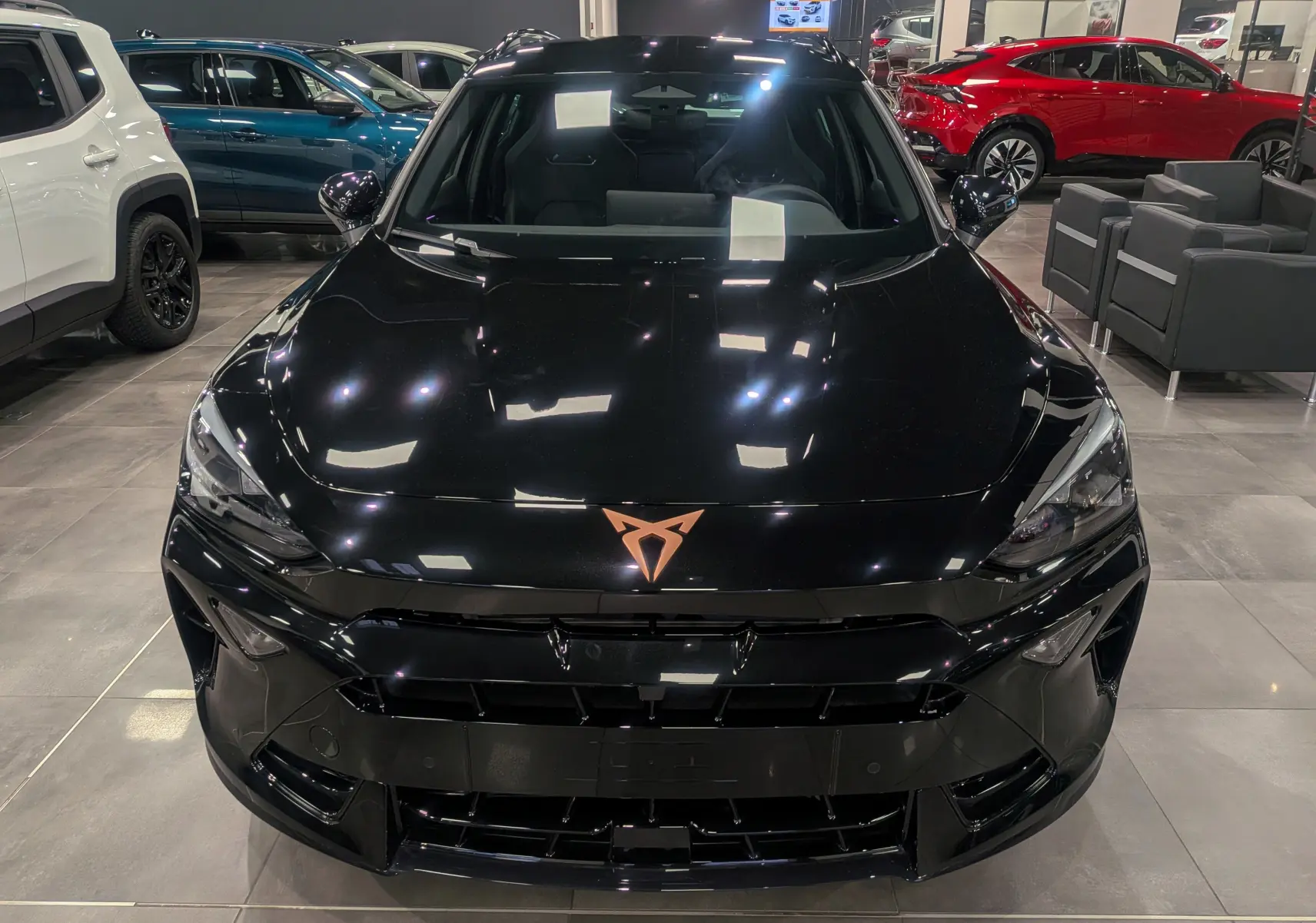 Vue avant d’une CUPRA Formentor eHybrid 2025 en noir minuit, avec logo cuivre distinctif sur le capot lisse.