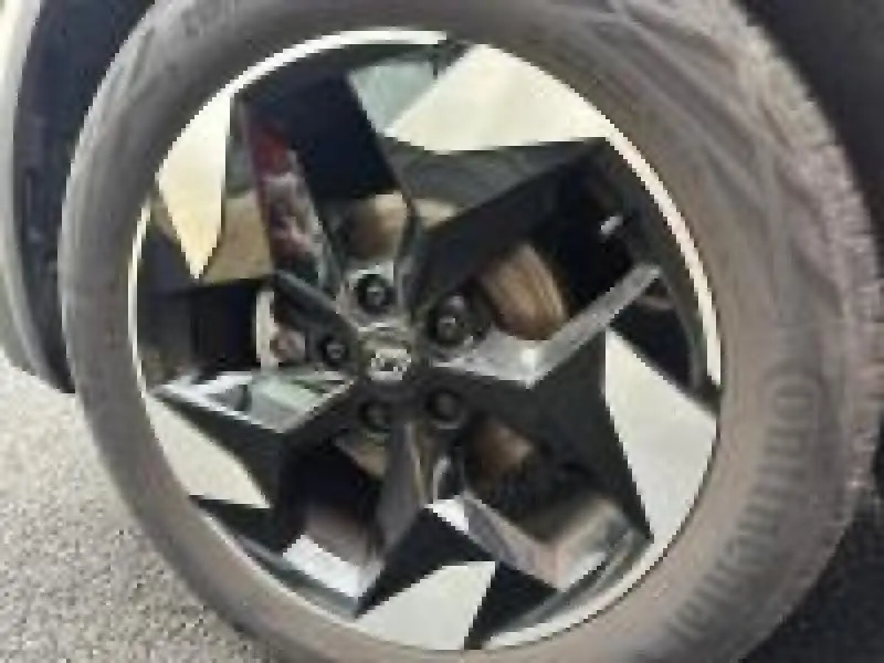 Gros plan sur la jante alu noire et argent du Renault Captur rouge 1.0 Eco-G 100ch Techno, vue côté roue avant.