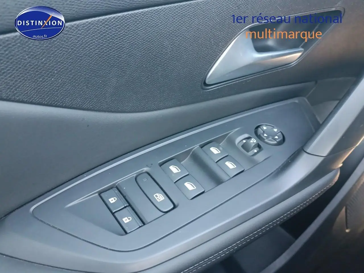 Gros plan sur la commande des vitres électriques côté conducteur de la Peugeot 408 Hybrid 145 gris sélénite.