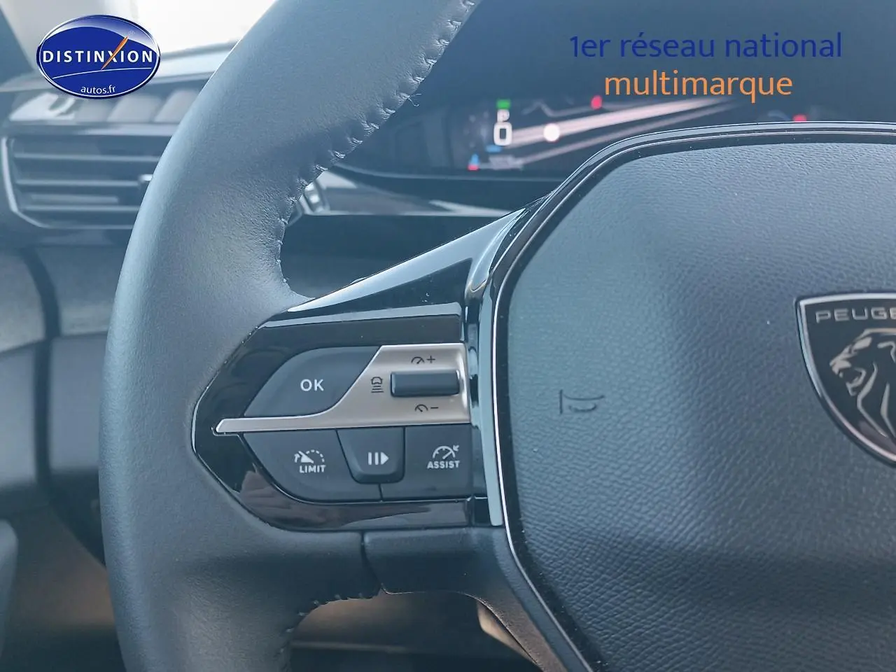 Gros plan sur le volant cuir de la Peugeot 408 Hybrid 145 allure gris sellenium, avec commandes intégrées et tableau de bord numérique.