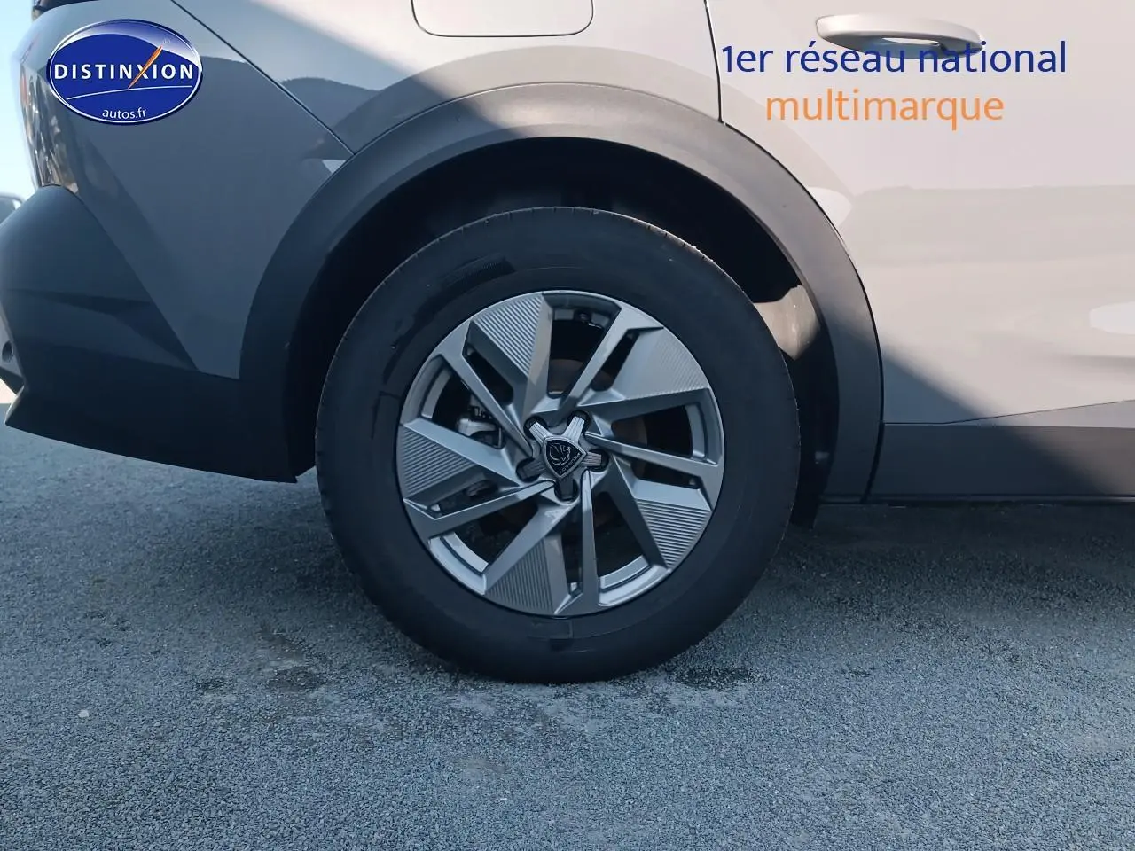 Gros plan sur la roue arrière gauche de la Peugeot 408 gris sélénite avec jante alu au design moderne.