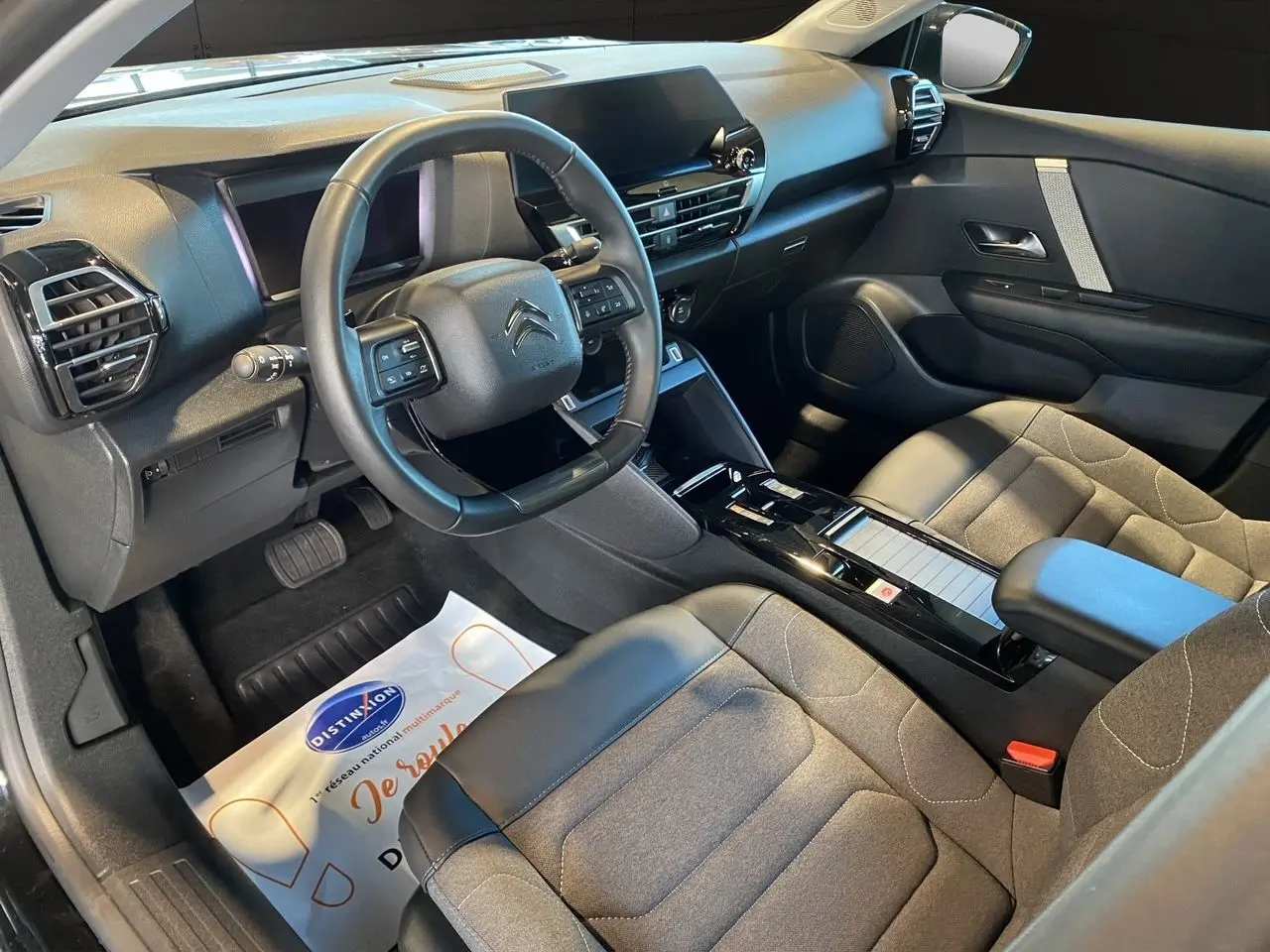 Intérieur avant droit du Citroën C4 2023 noir Perla Nera, avec tableau de bord moderne et sièges gris noir.